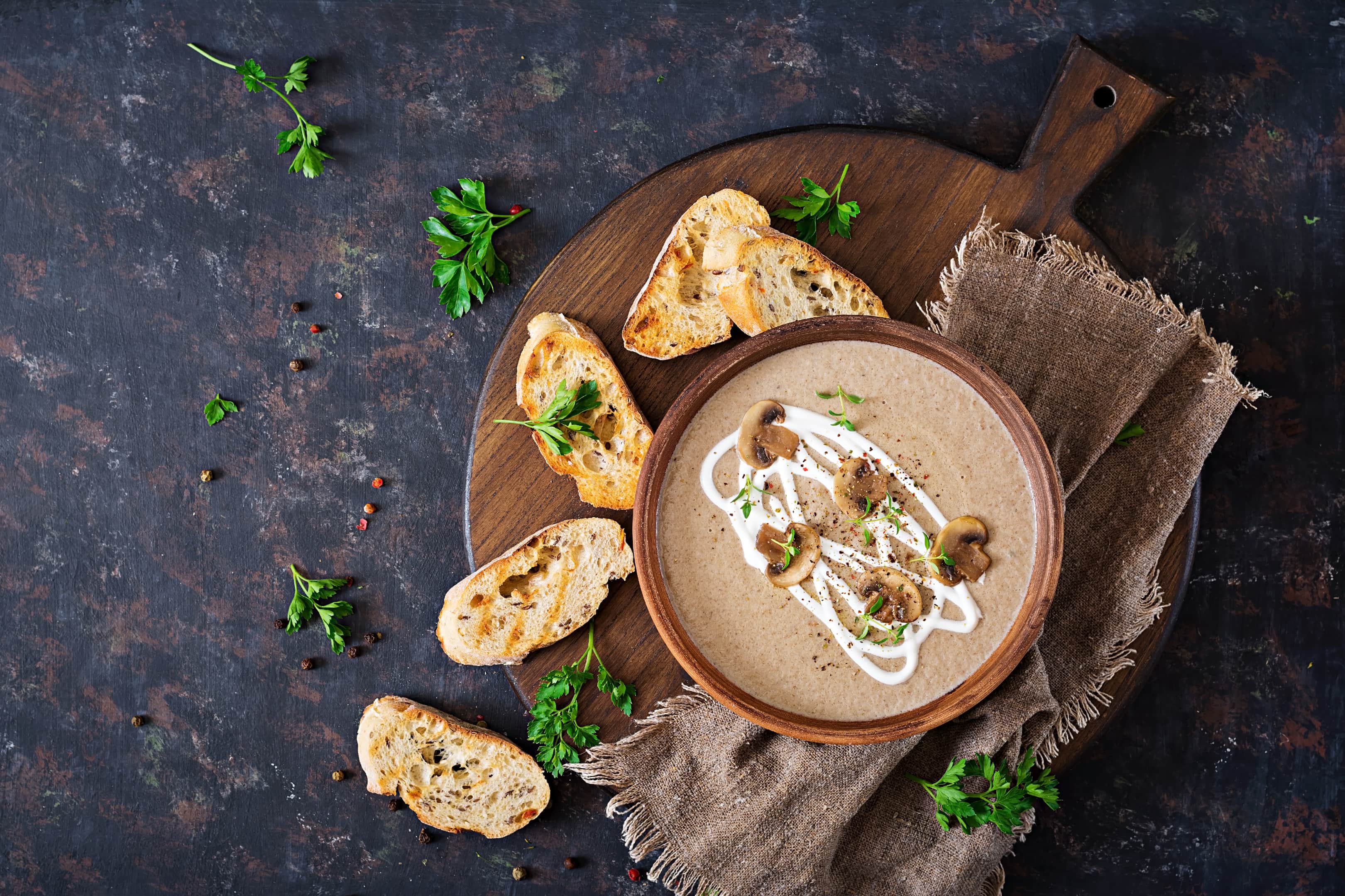 Mushroom cream puree in ceramic bowl on wooden board