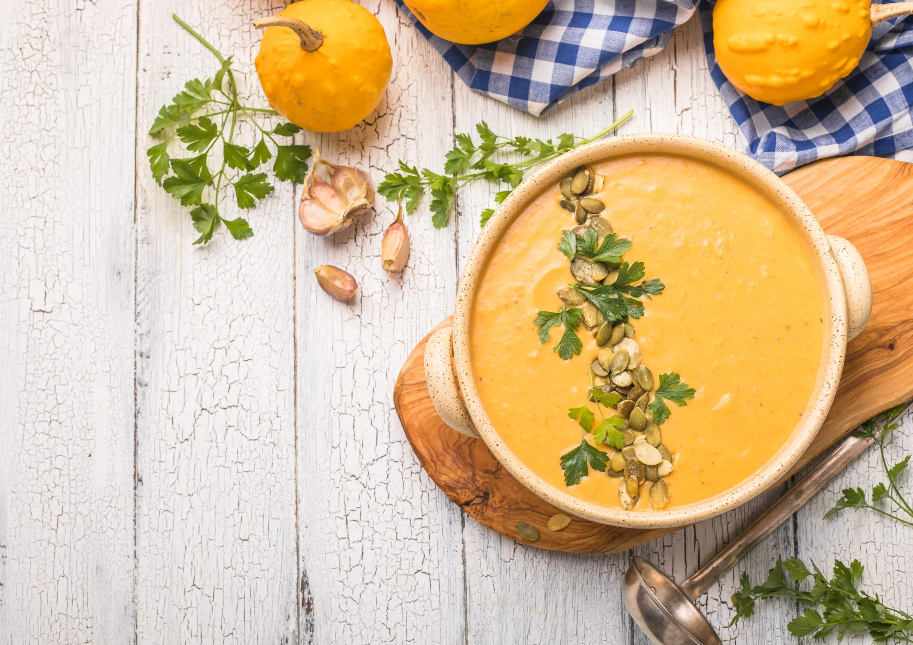 Pumpkin soup with roasted pumpkin seeds on white wooden table
