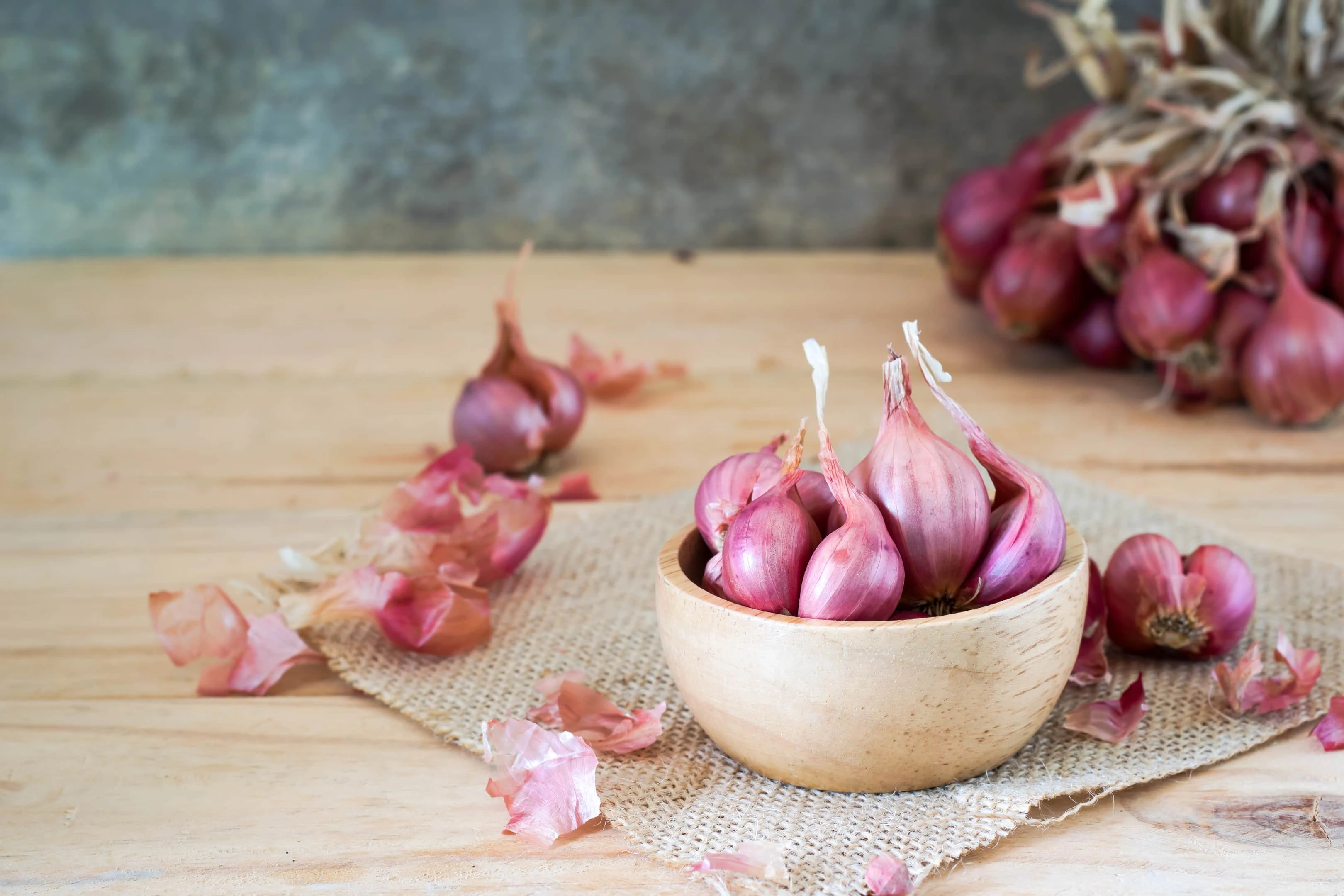 Shallots in bowl on wooden table and shallots bouquet