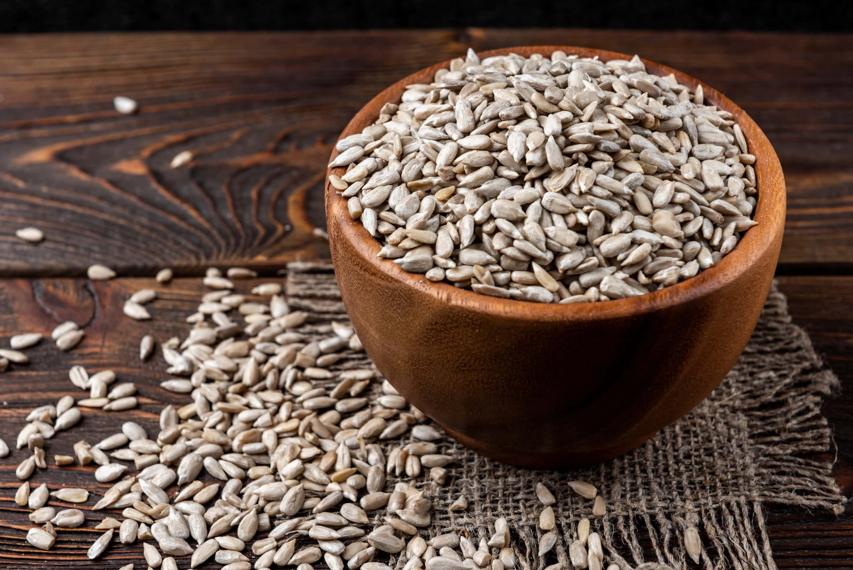 Sunflower seeds in wooden bowl on wooden table