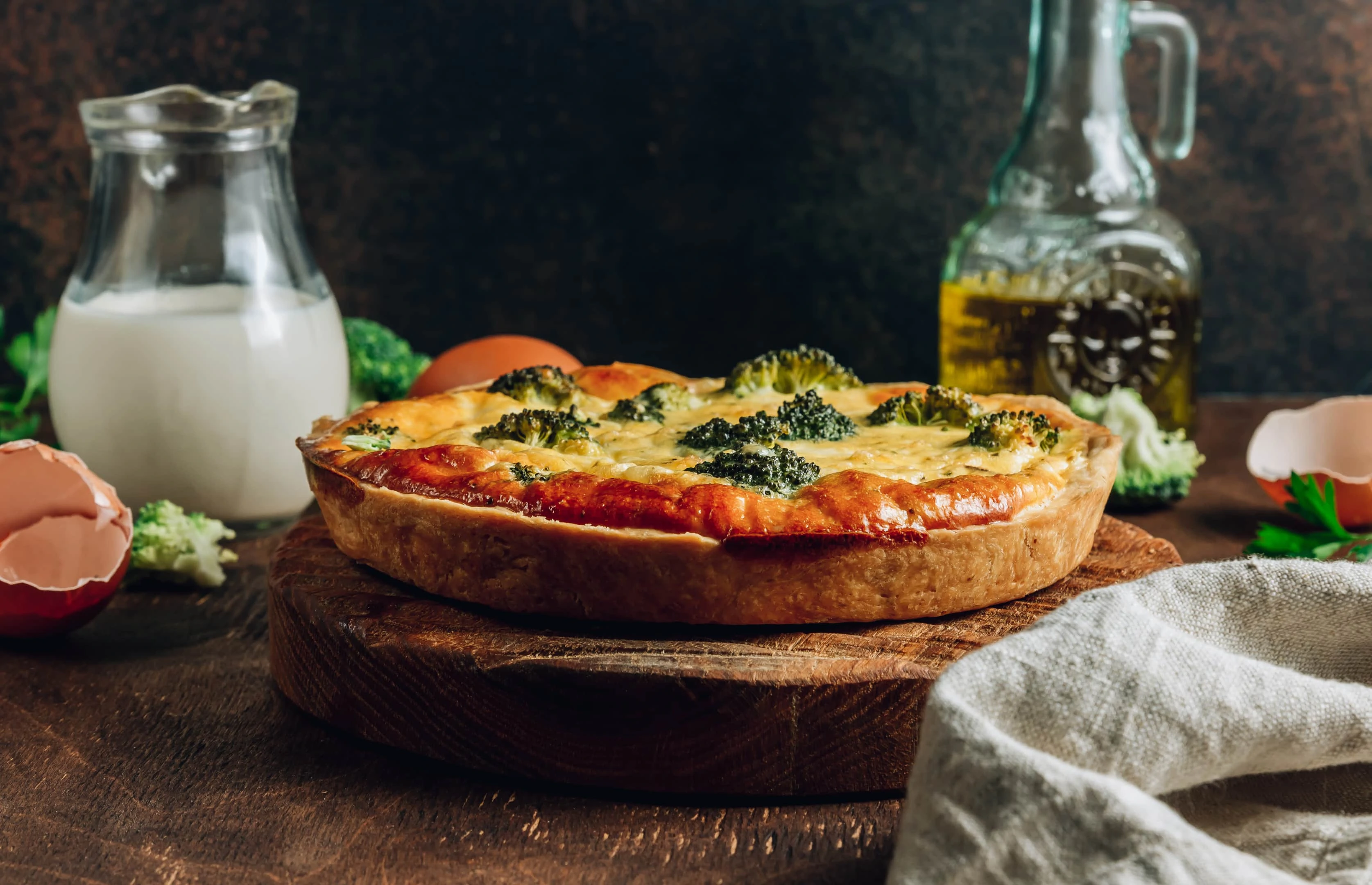 Traditional vegetable quiche with broccoli on wooden board