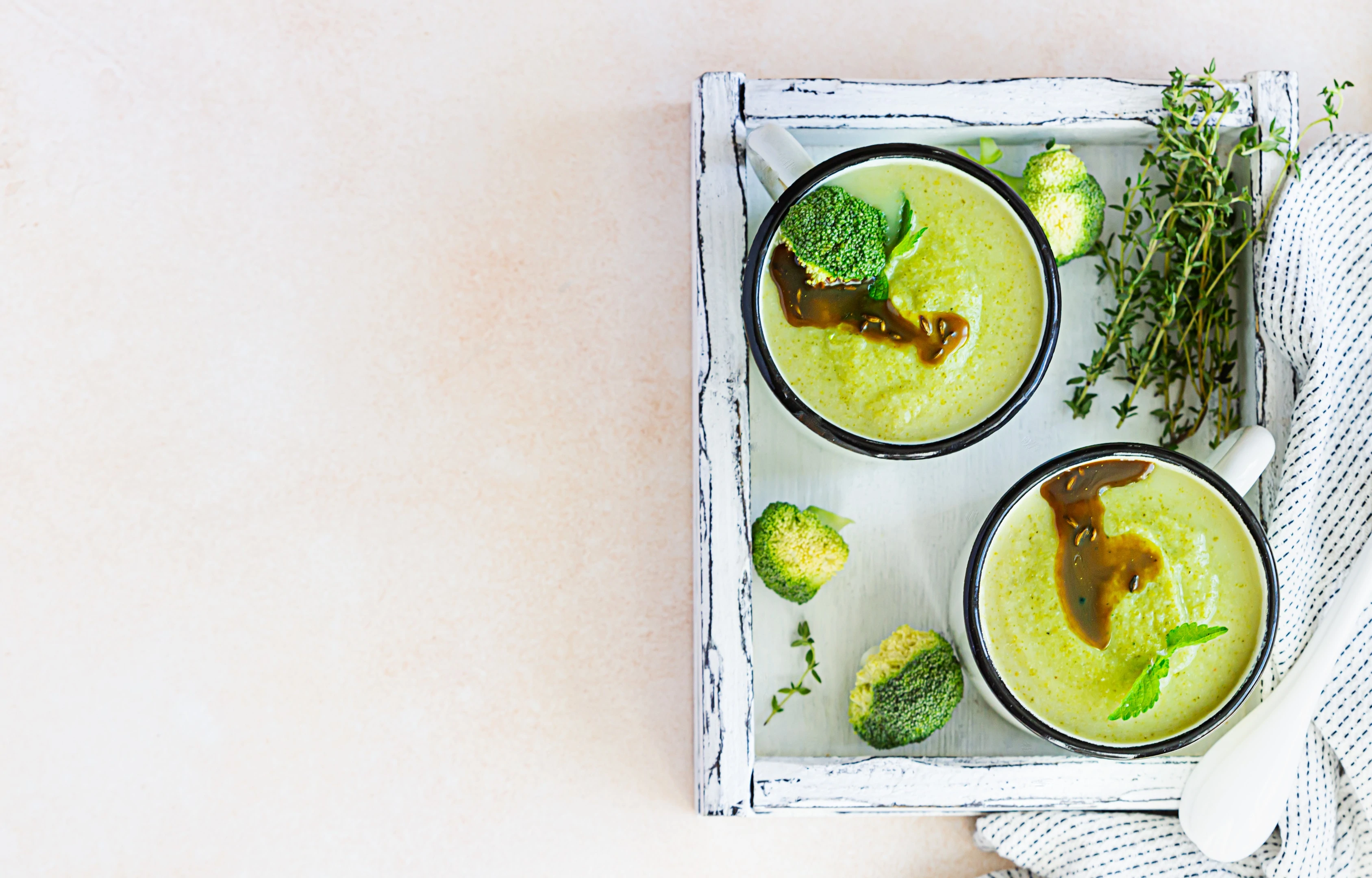 Two enamel mugs with healthy vegan broccoli soup puree