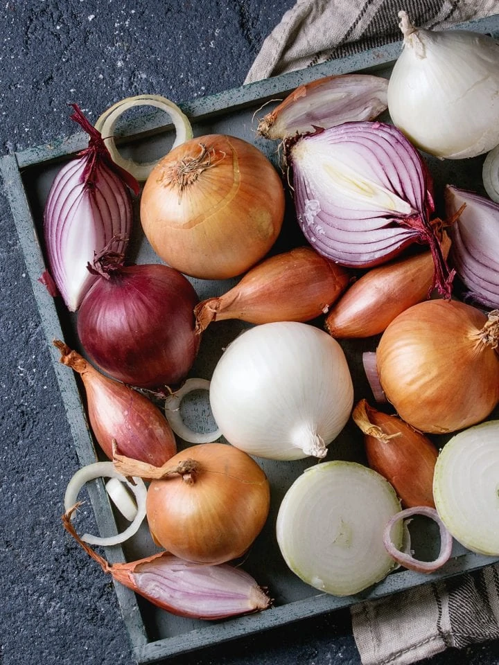 Variety of whole and sliced onion and shallots