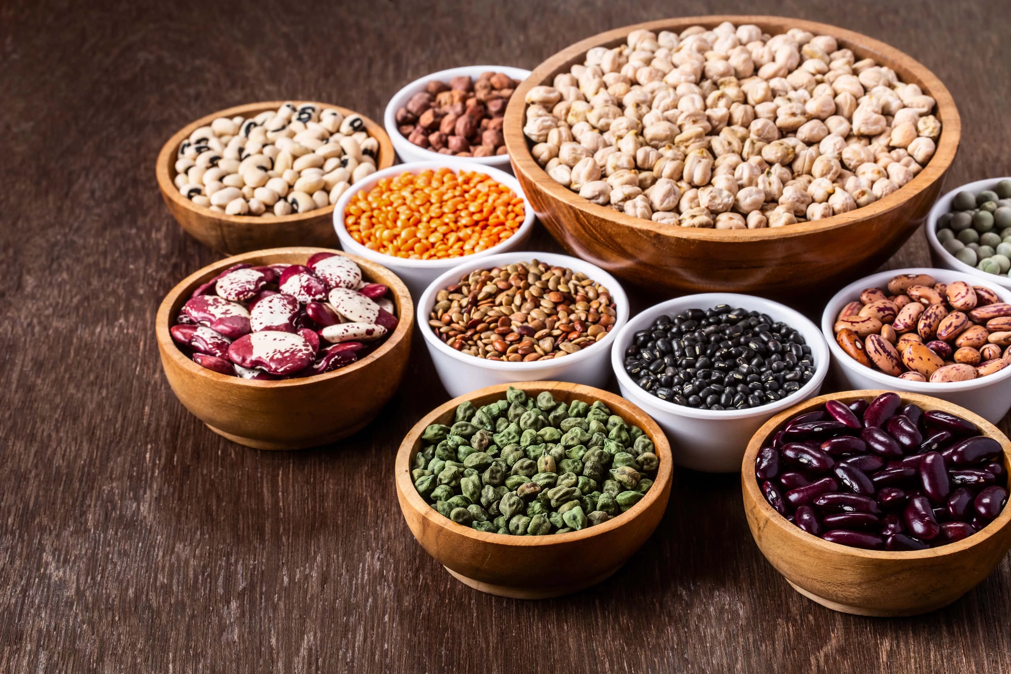 Various assortment of legumes in bowls wooden on wooden table