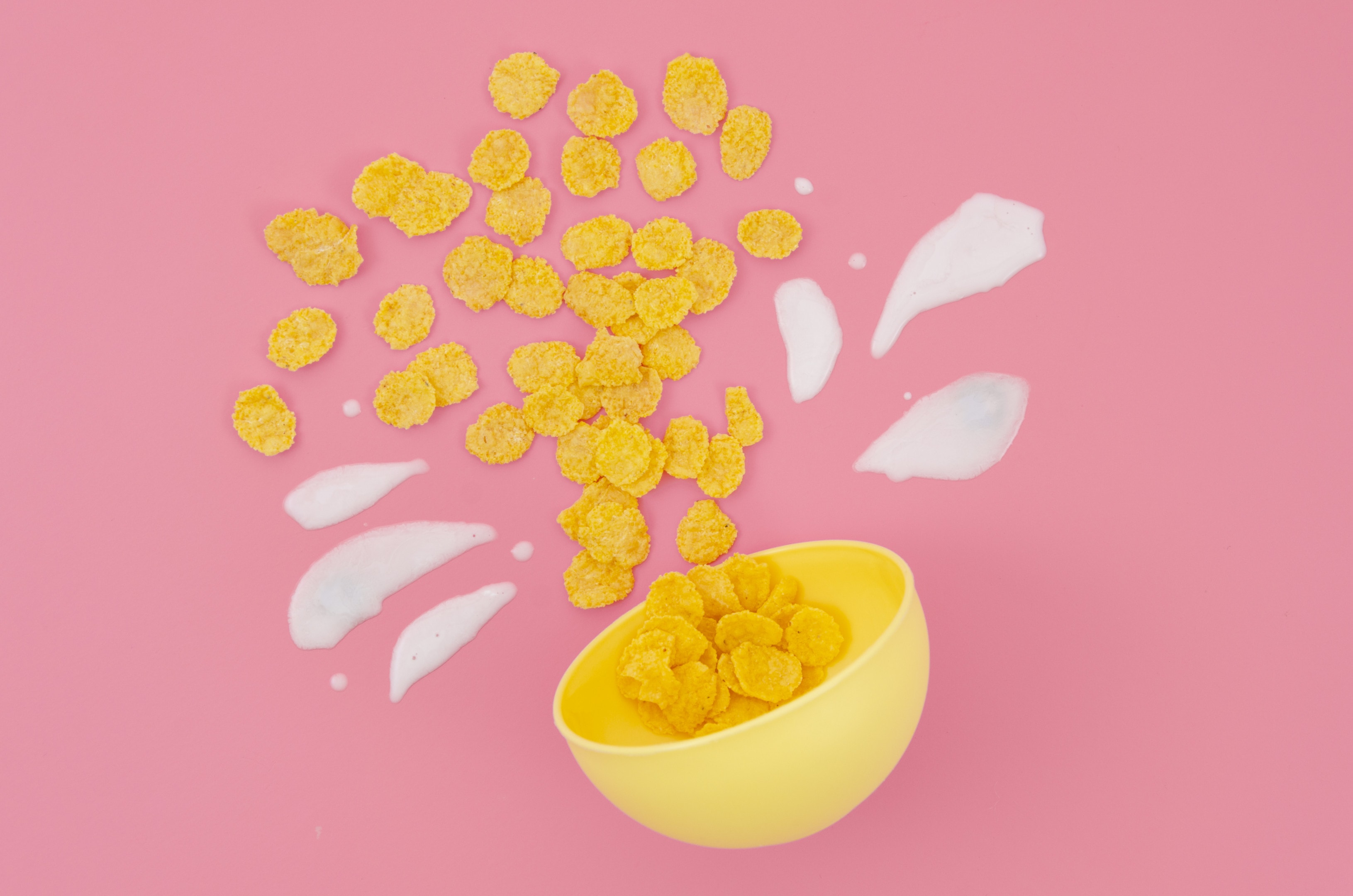 Cereal and milk arrangement on pink background
