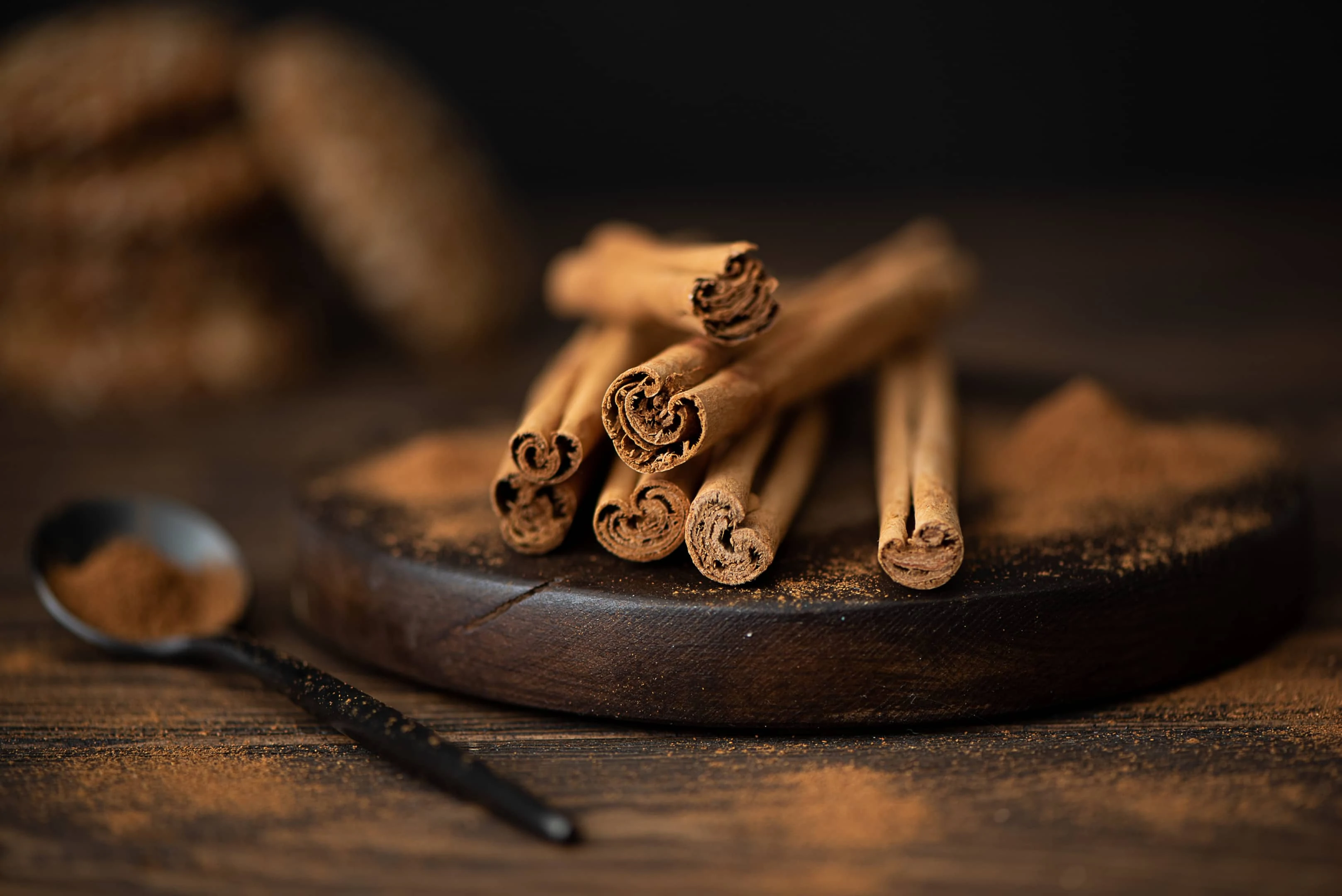 Cinnamon sticks and powder on wooden board