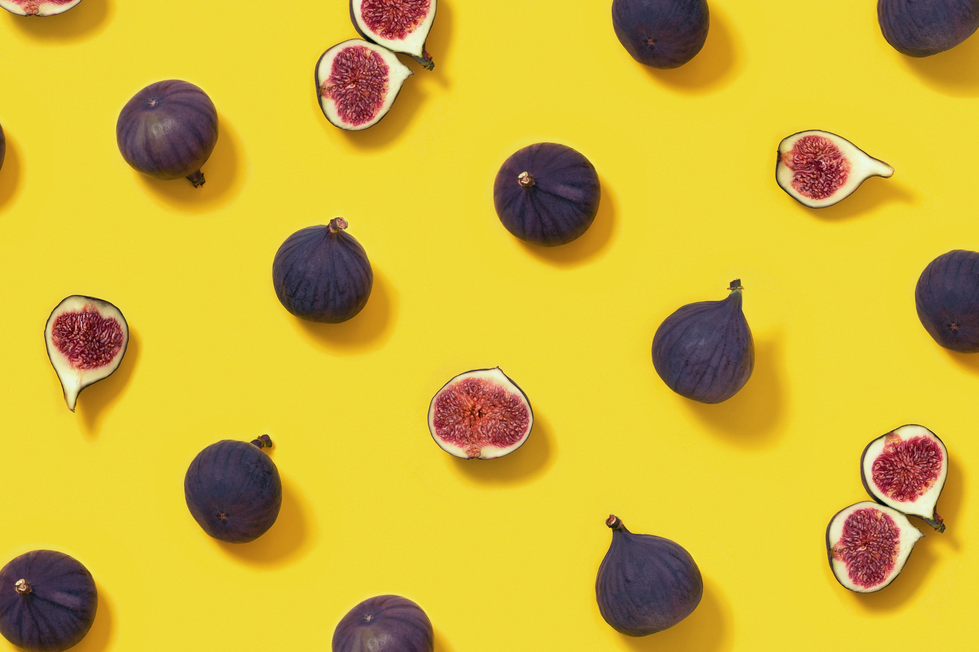 Fresh figs whole and sliced figs on yellow background