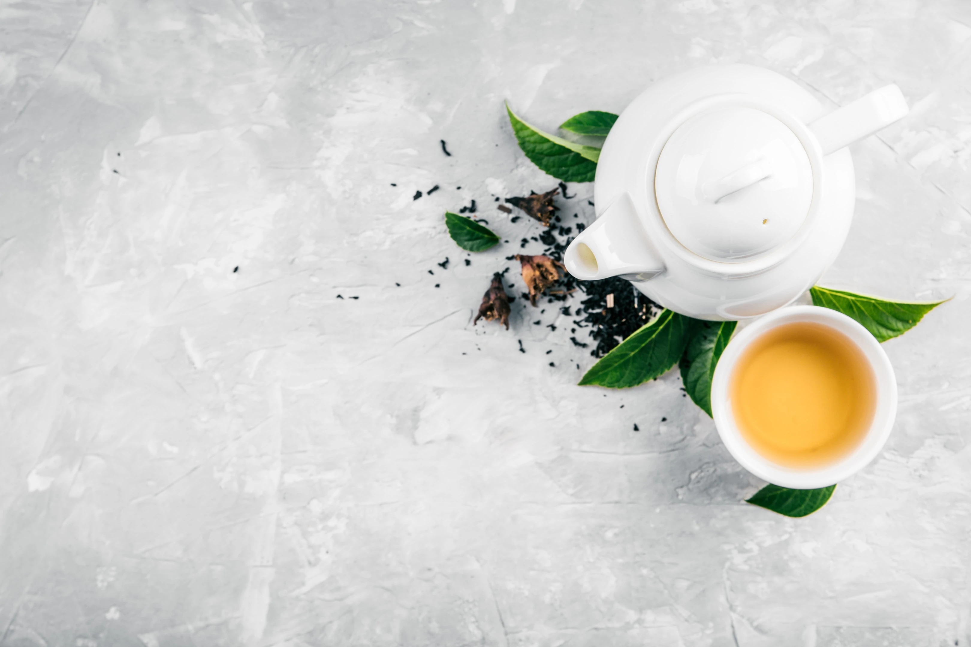 Herbal tea cup and teapot on concrete background