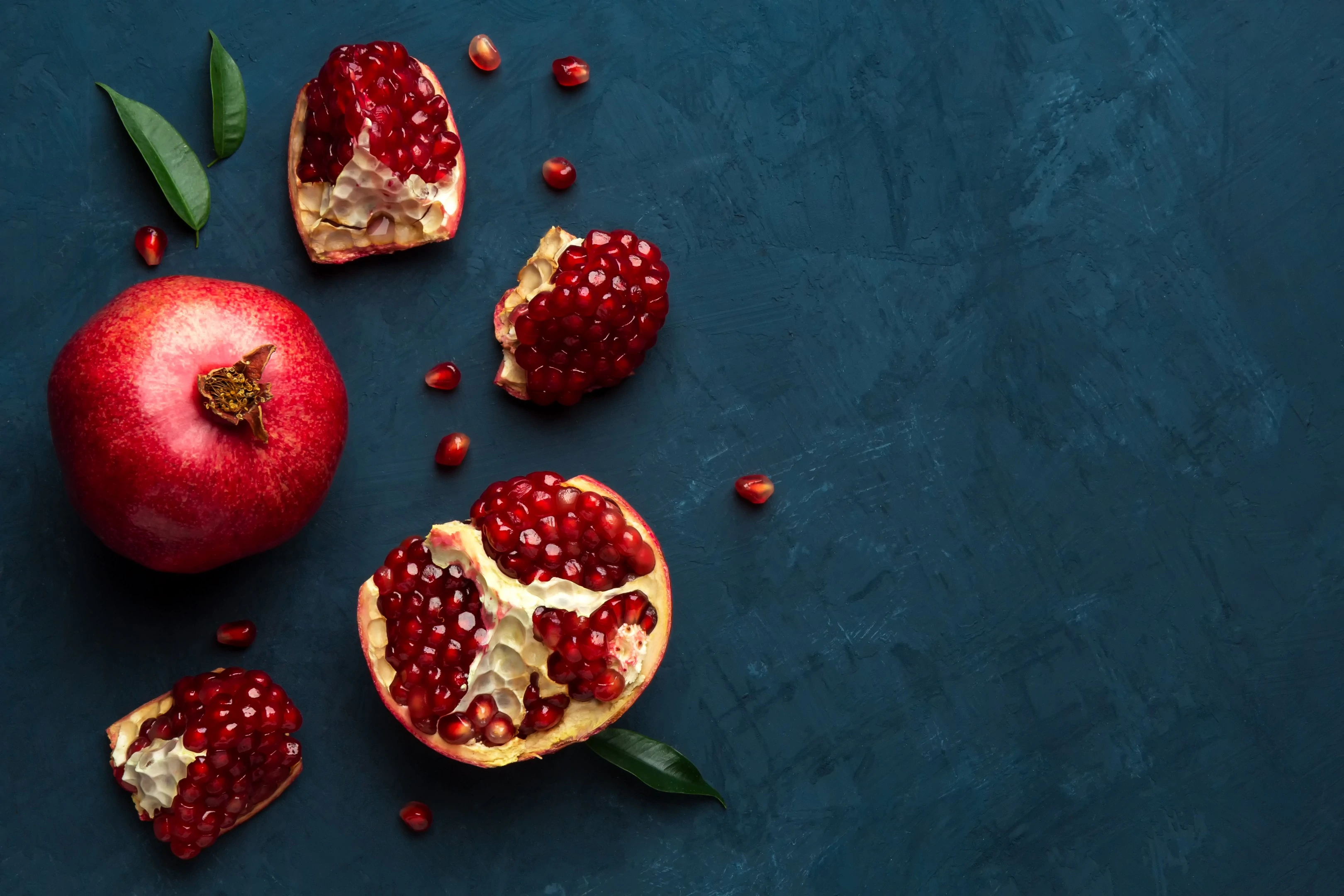 Juicy fresh pomegranate on blue wooden table