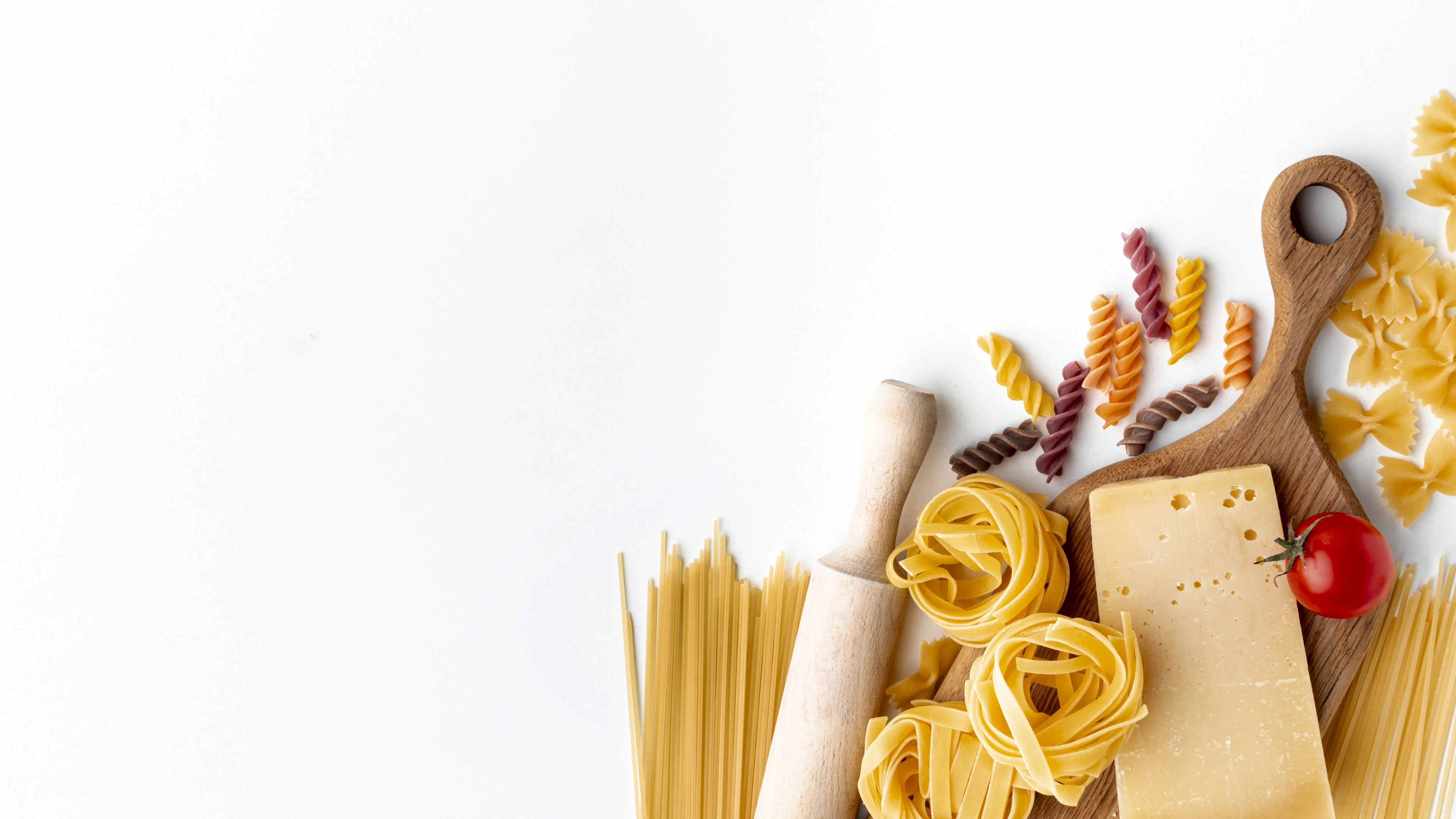 Mix of uncooked pasta and hard cheese on white background