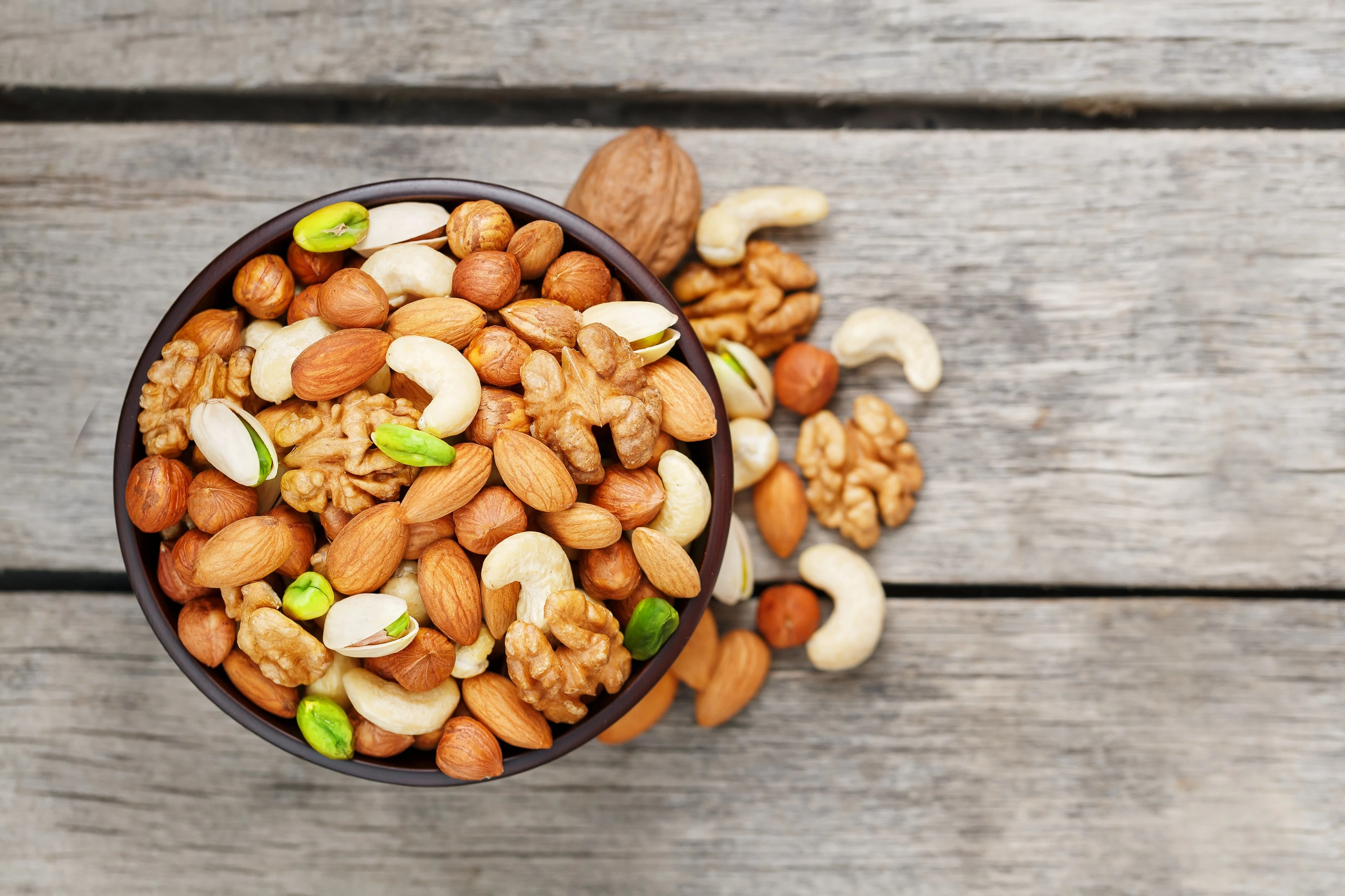 Mixed nuts walnut pistachios almonds hazelnuts cashews in wooden bowl