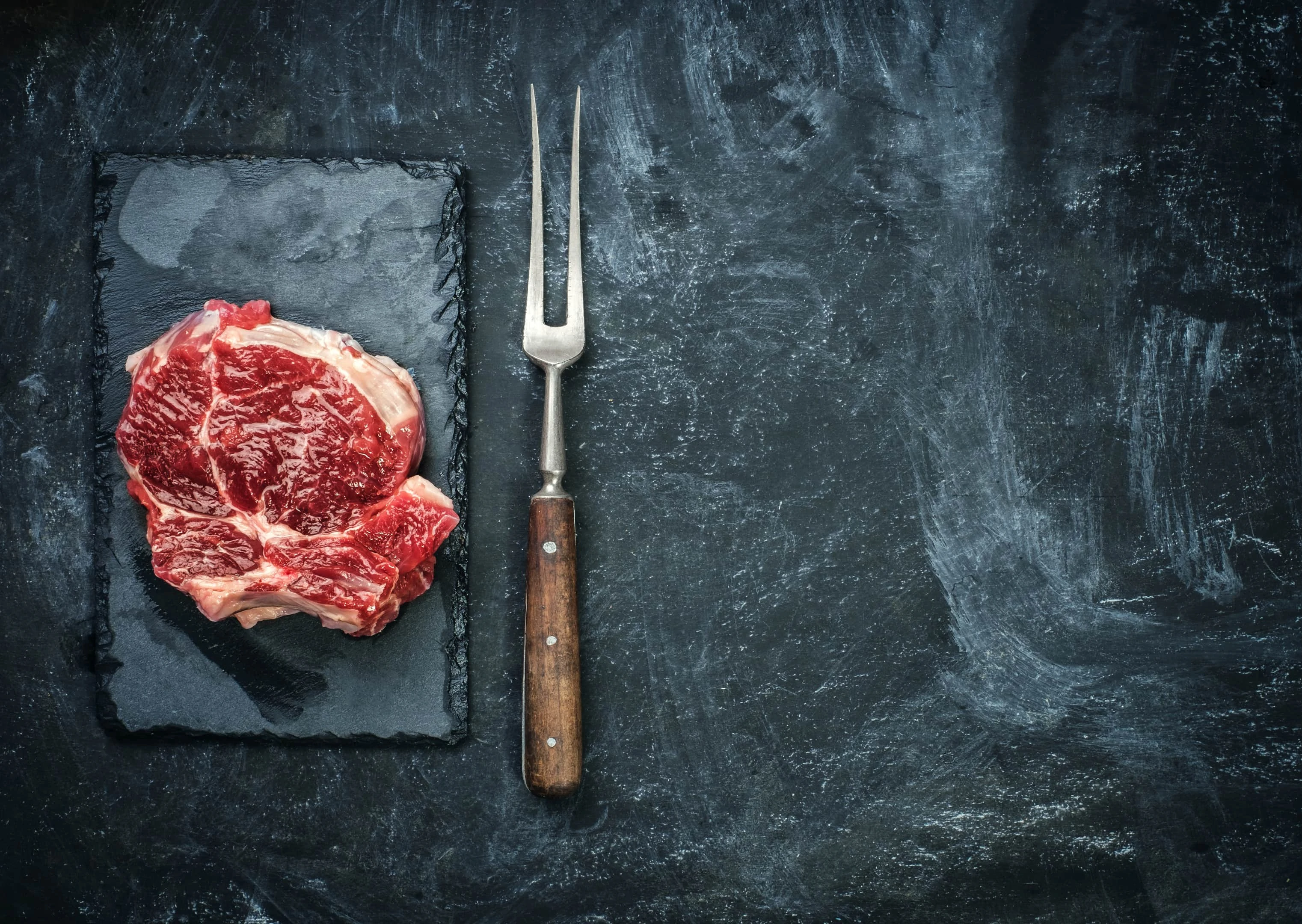 Raw lean beef steak on stone plate