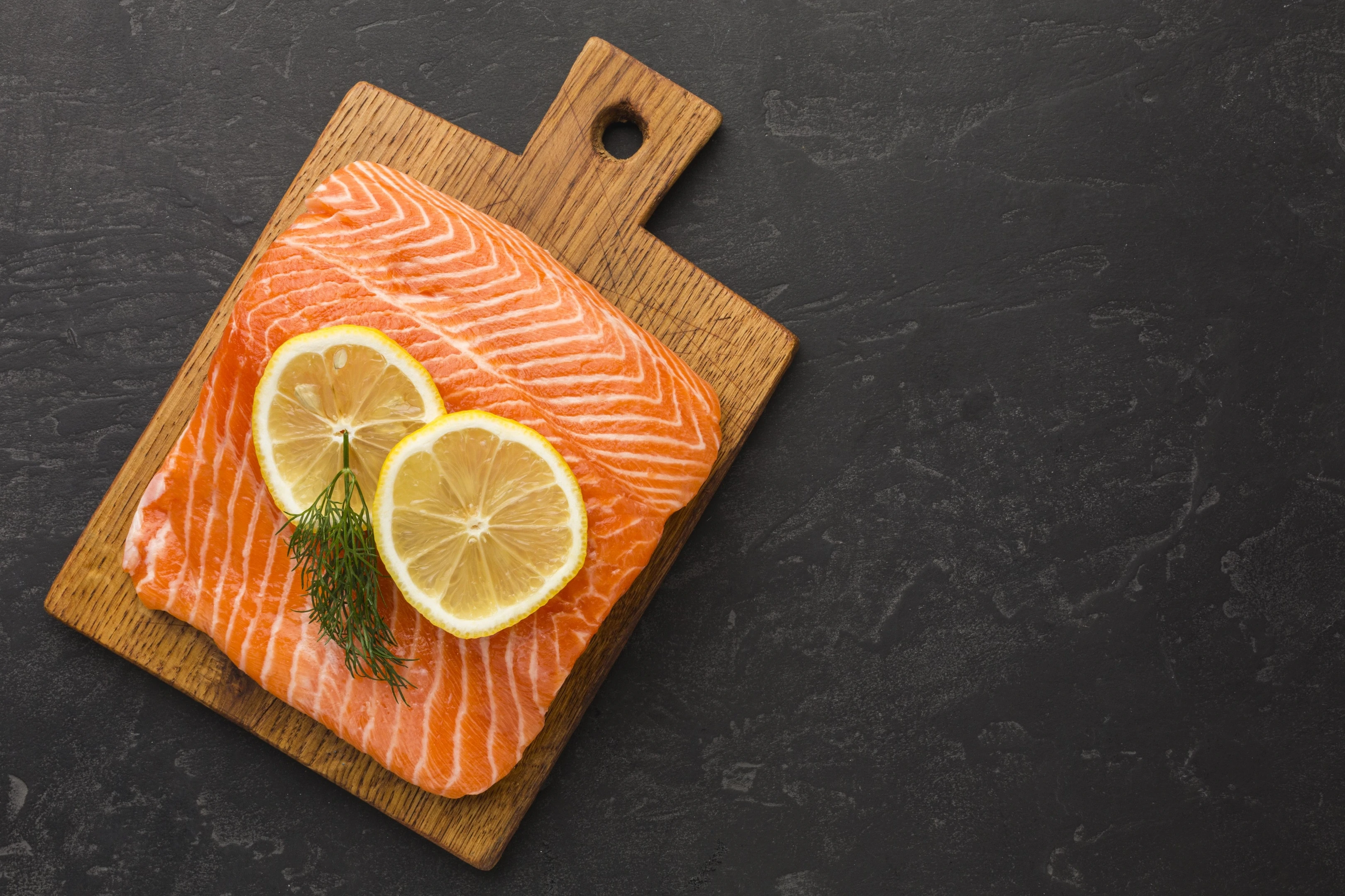 Salmon and lemon on wooden board