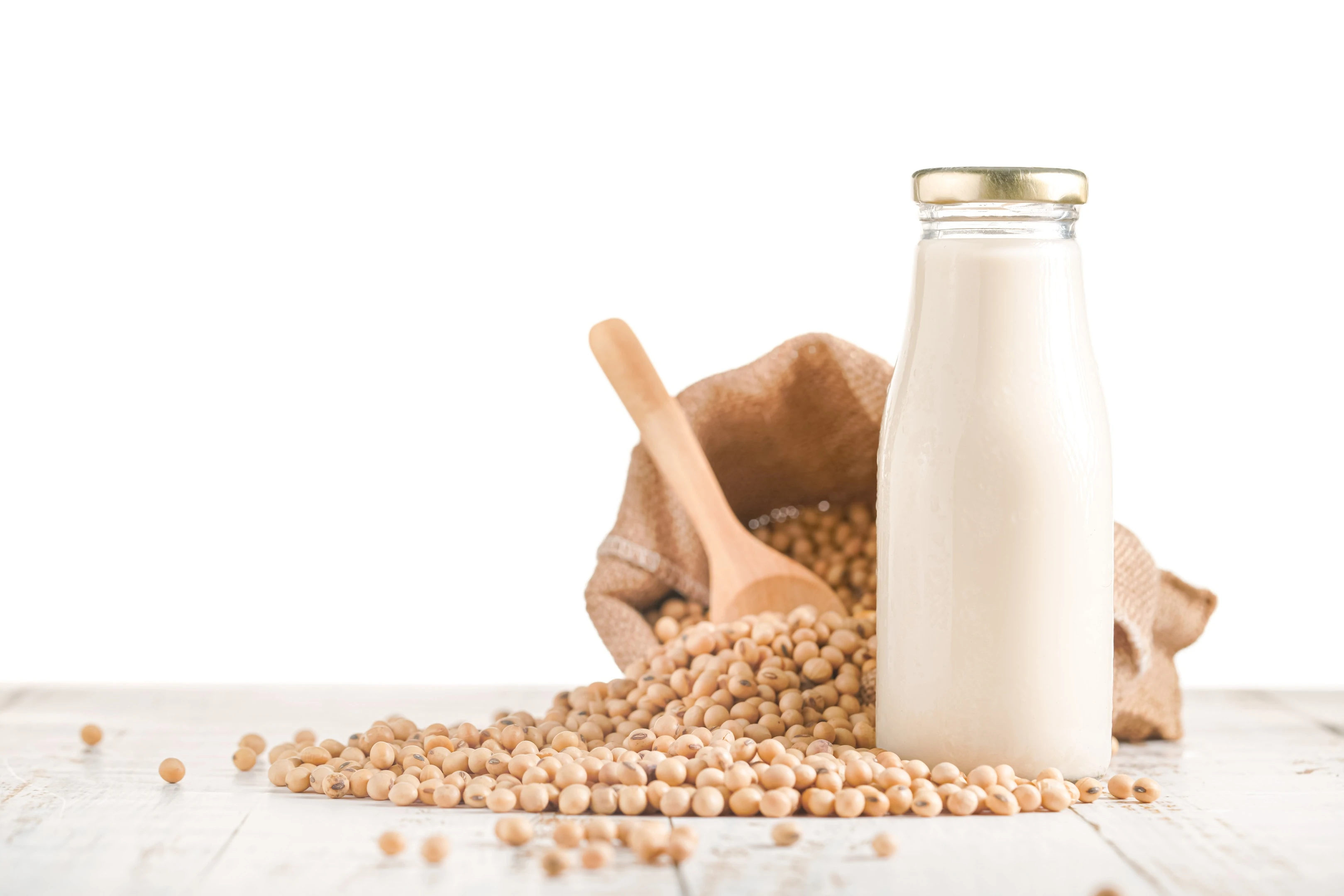 Soy beans and bottle of soy milk on white background