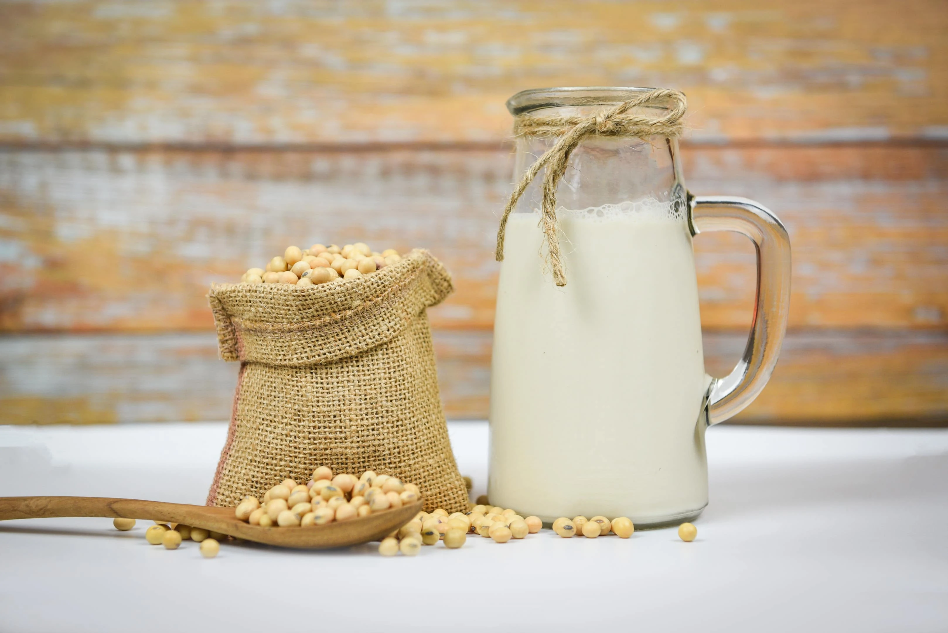 Soy beans and soy milk on white table