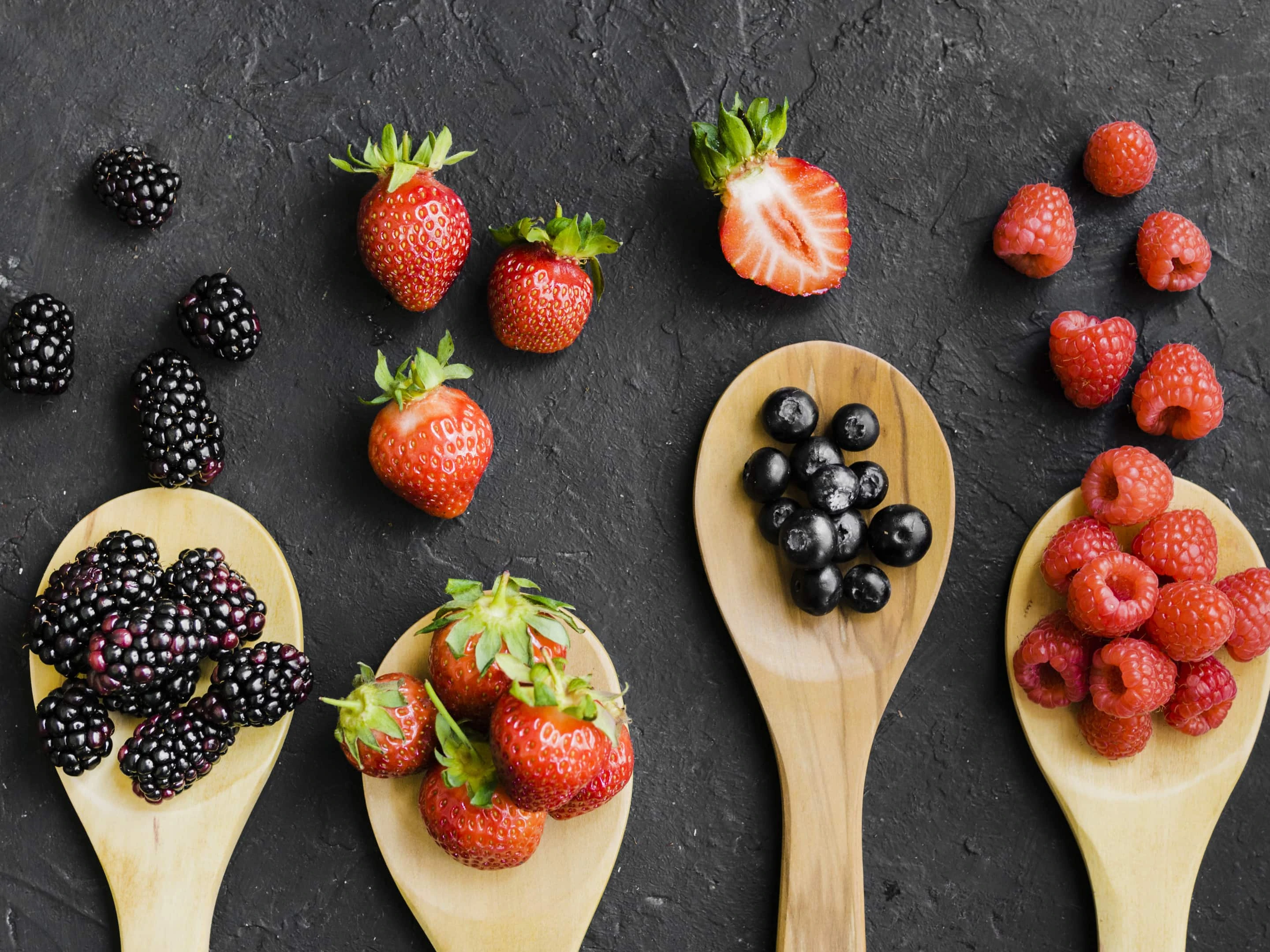 Variety of berries on wooden spoons