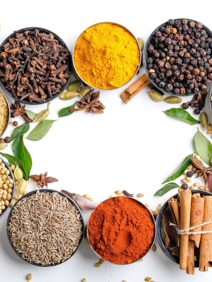 Various spices in bowls on white background
