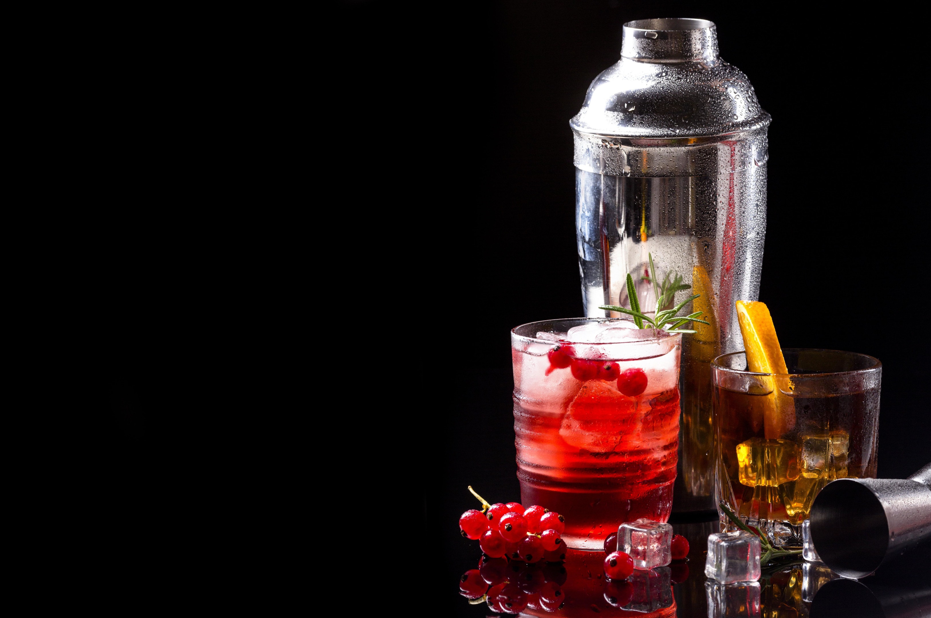 Vodka cranberry and whiskey with orange on black background