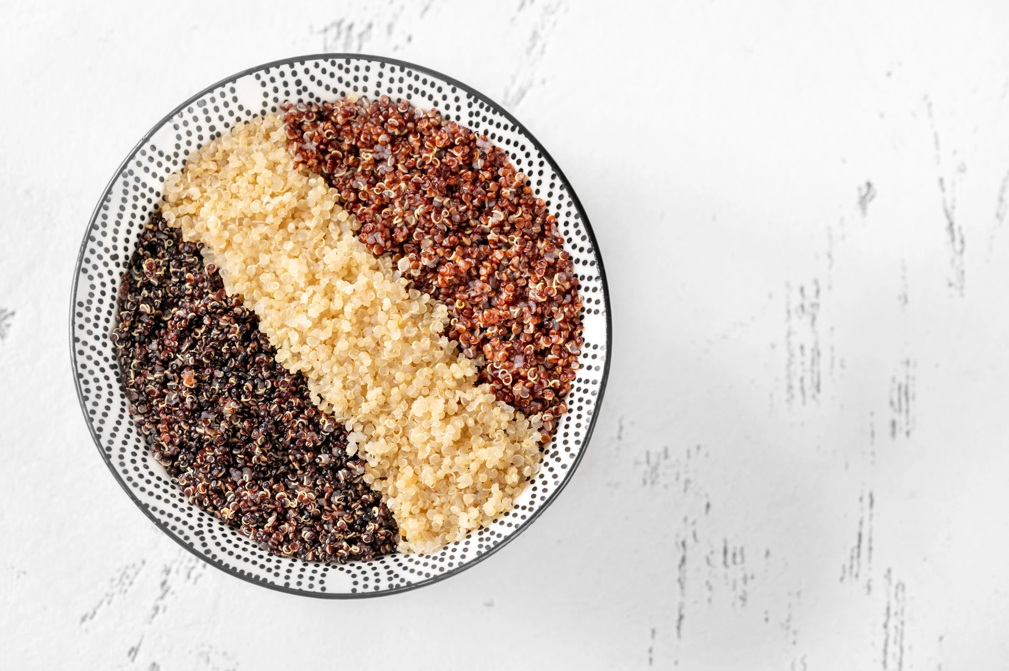 Bowl with white red and black cooked quinoa