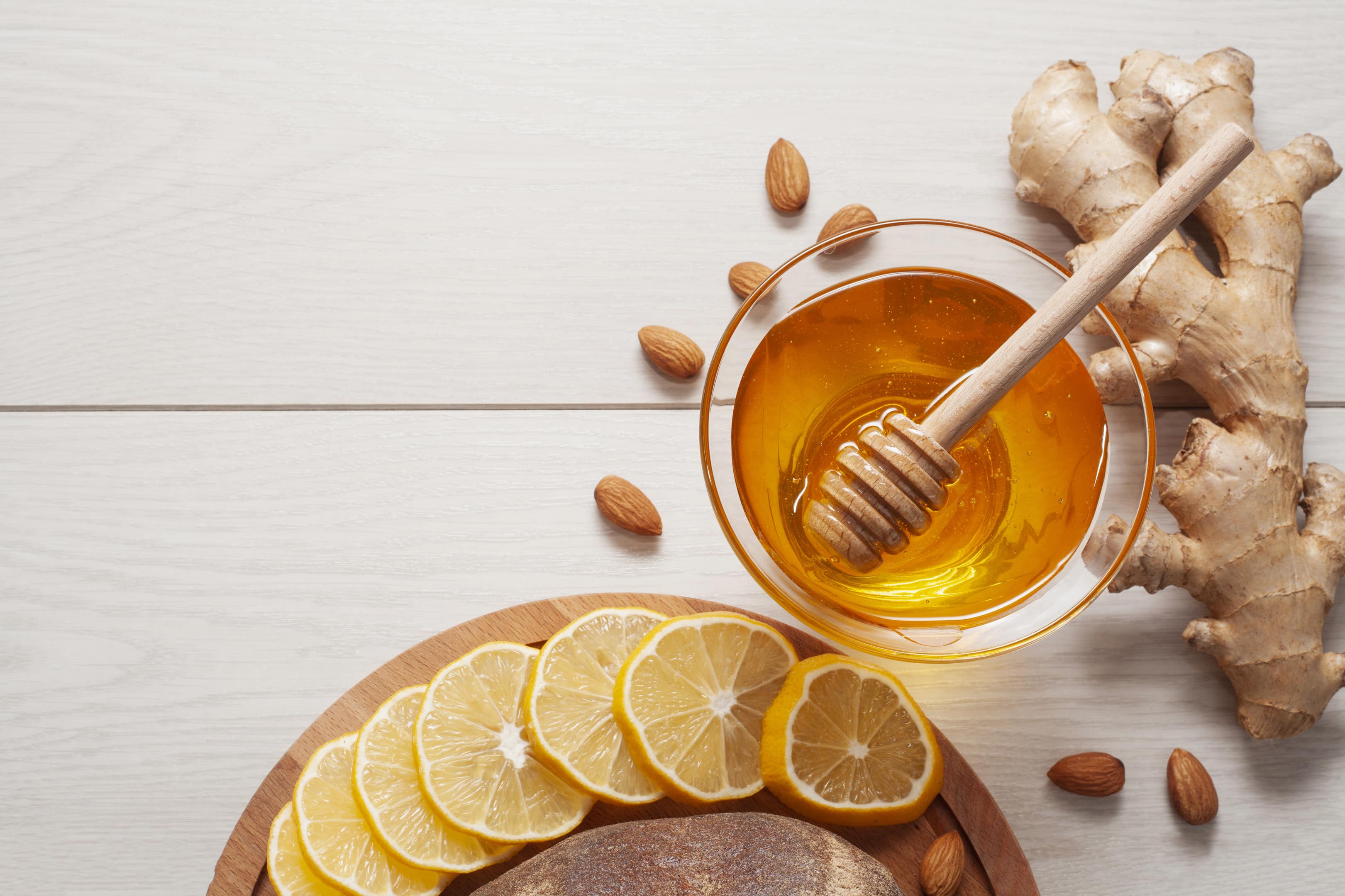 Honey with ginger and lemon on wooden table