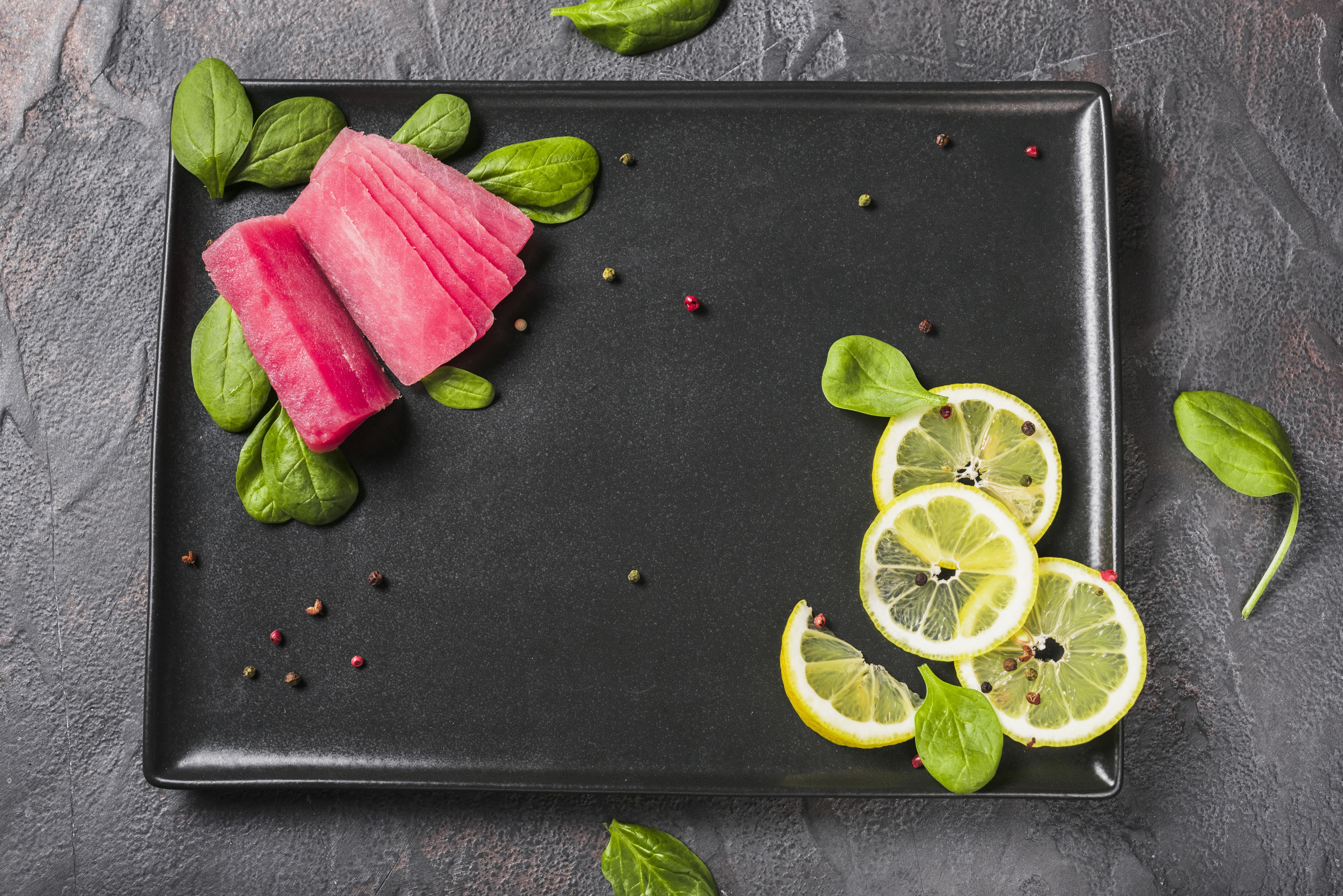 Raw tuna fillet with basil leaves and lemon