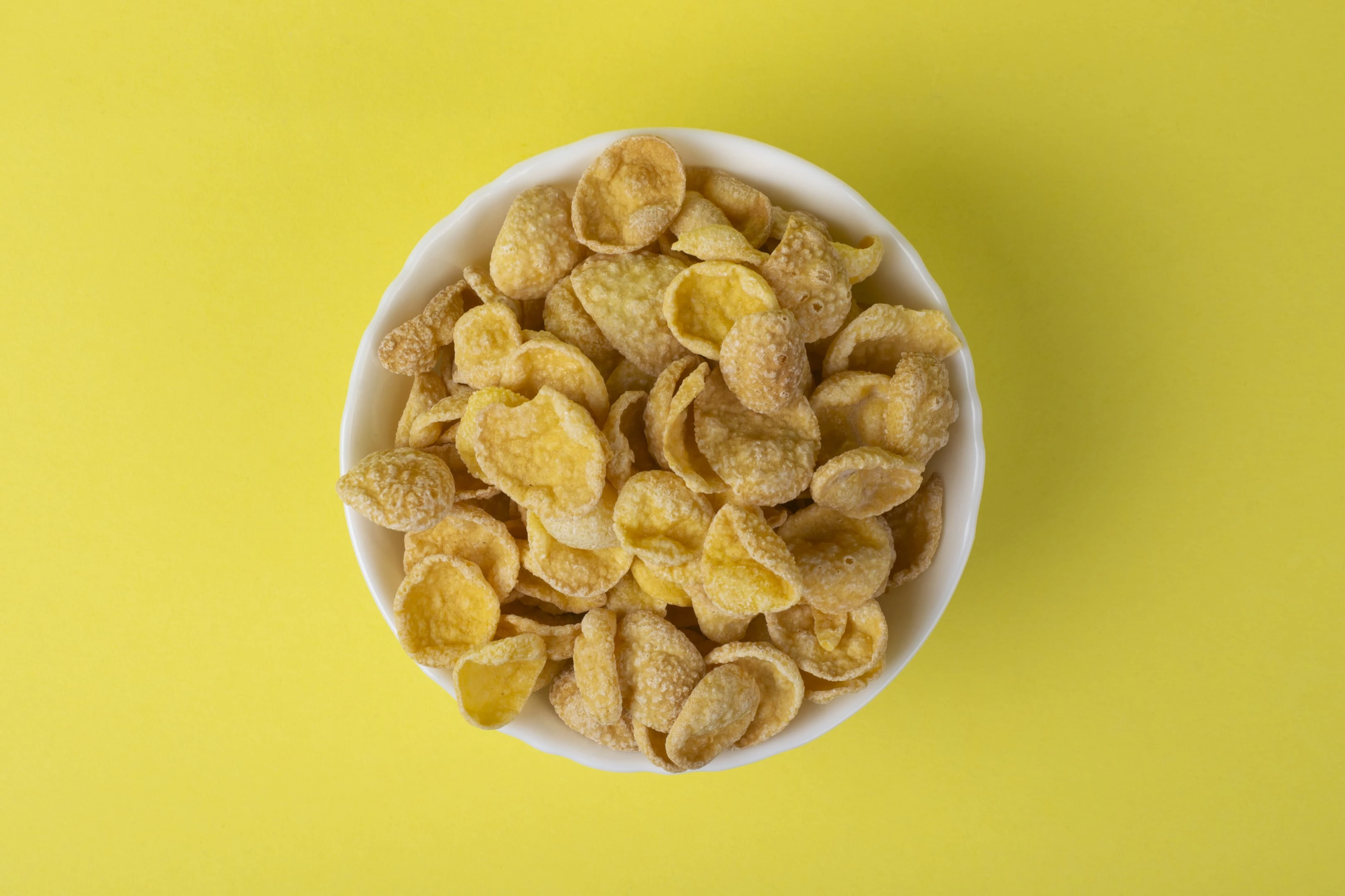 Bowl of Cornflakes on Yellow Table
