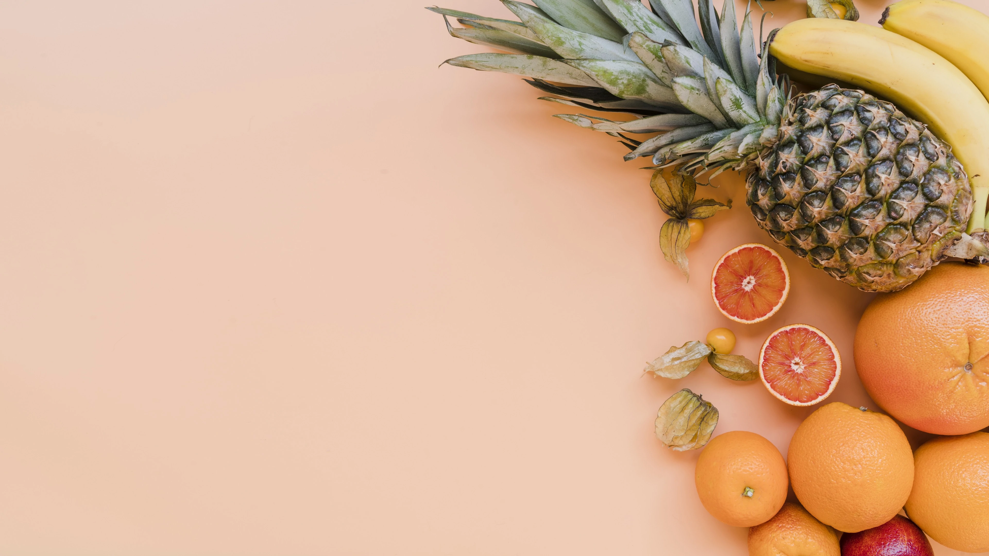 Delicious fresh fruits on orange background