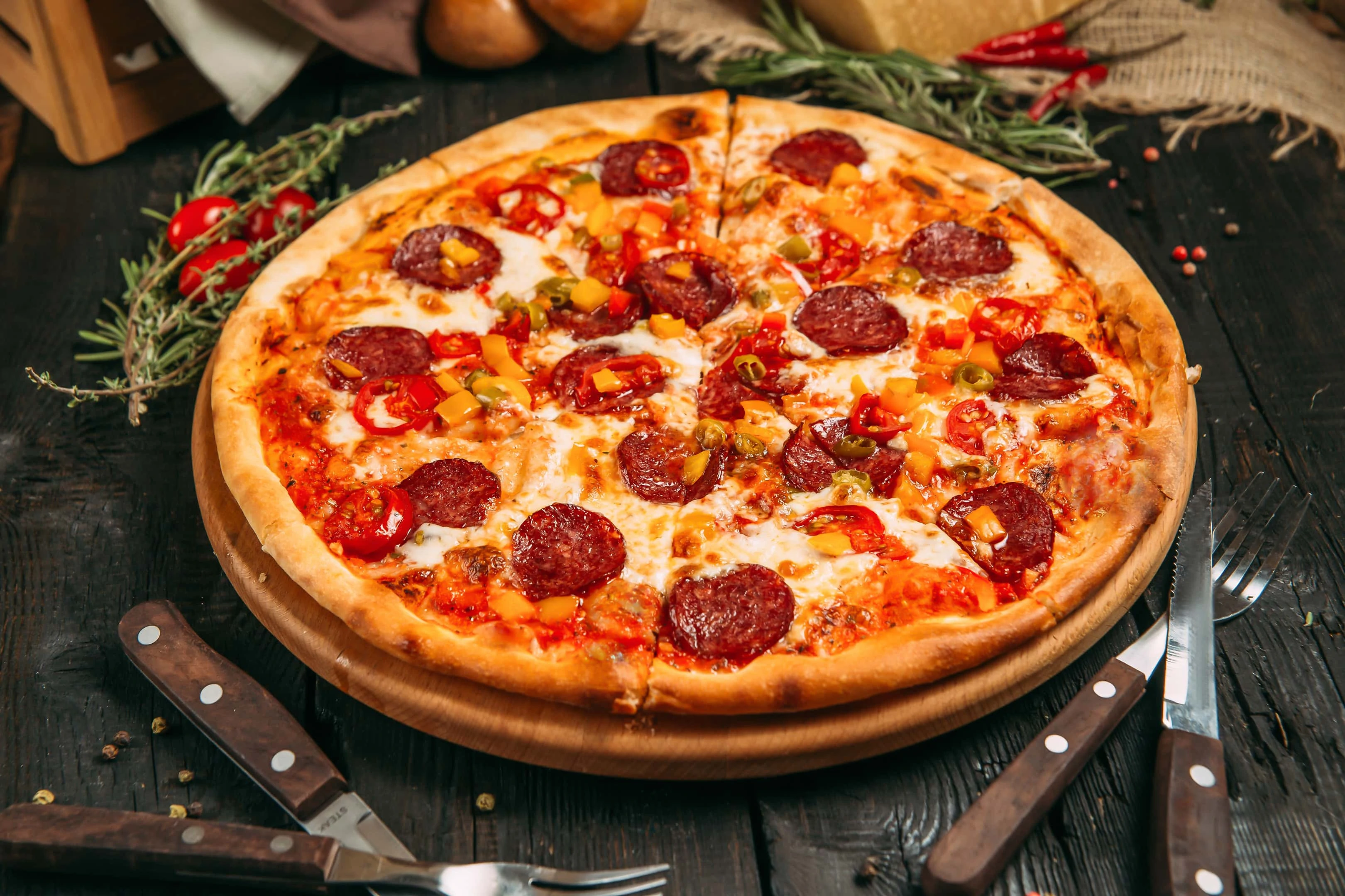 Delicious savory pizza with pepperoni and pepper on dark wooden table