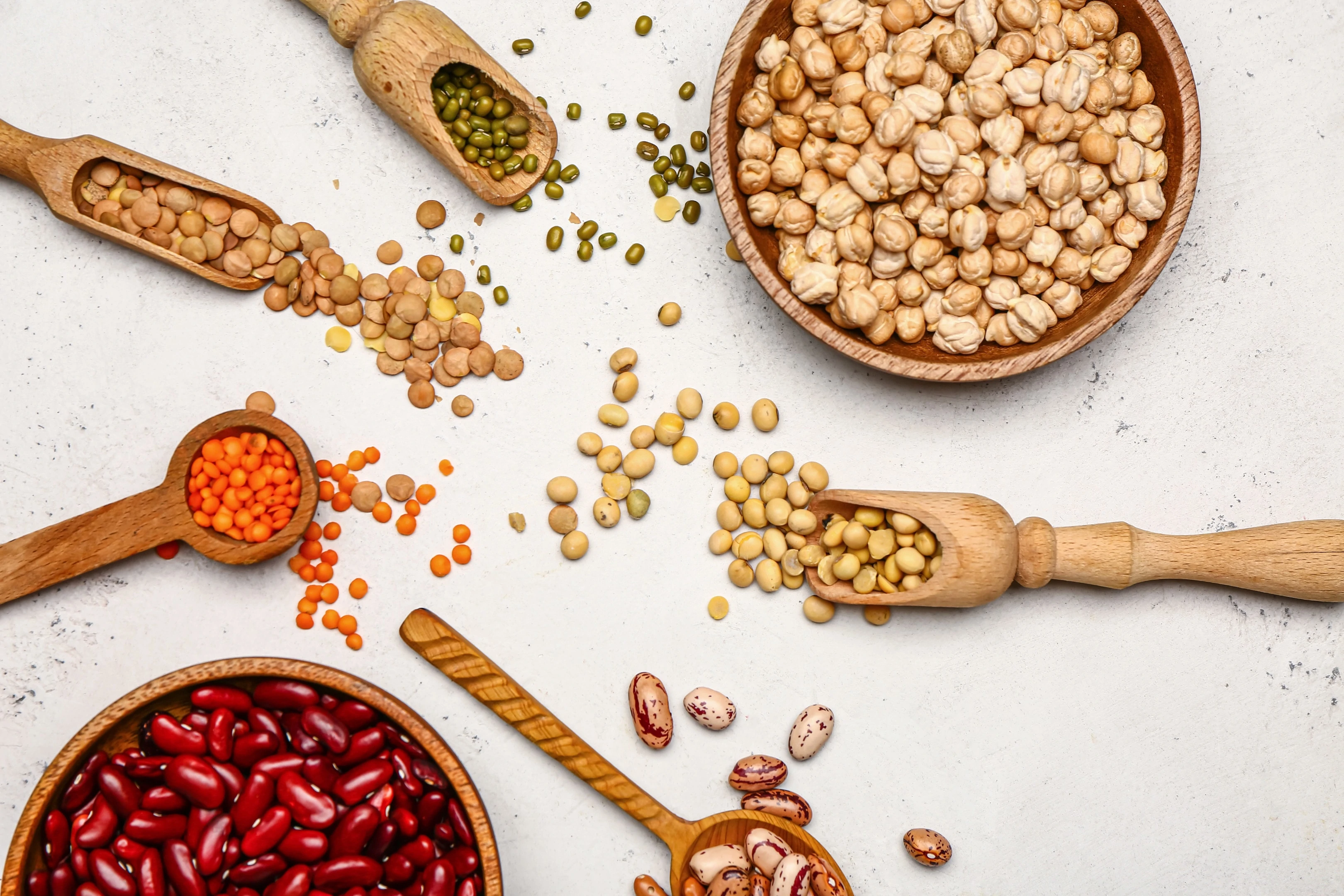 Different raw legumes on white table
