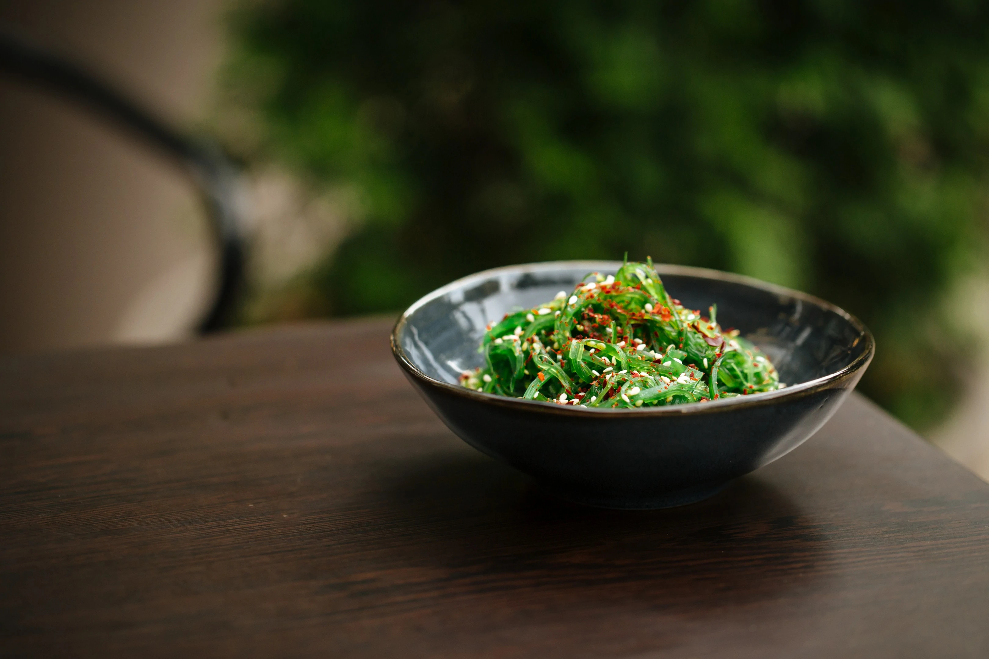 Green chuka seaweed salad in black bowl