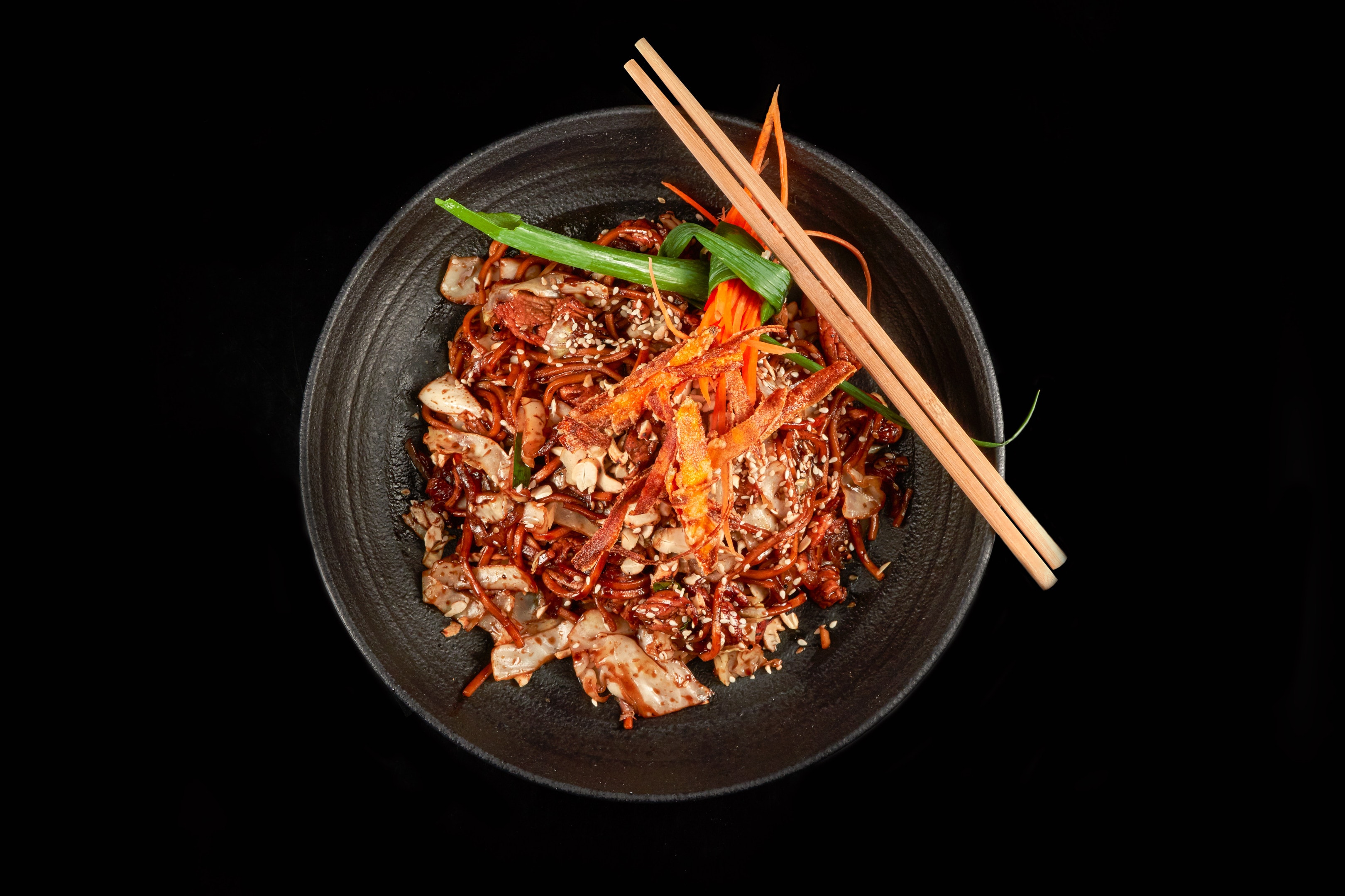 Stir-fry noodles seasoned with rice vinegar in black bowl
