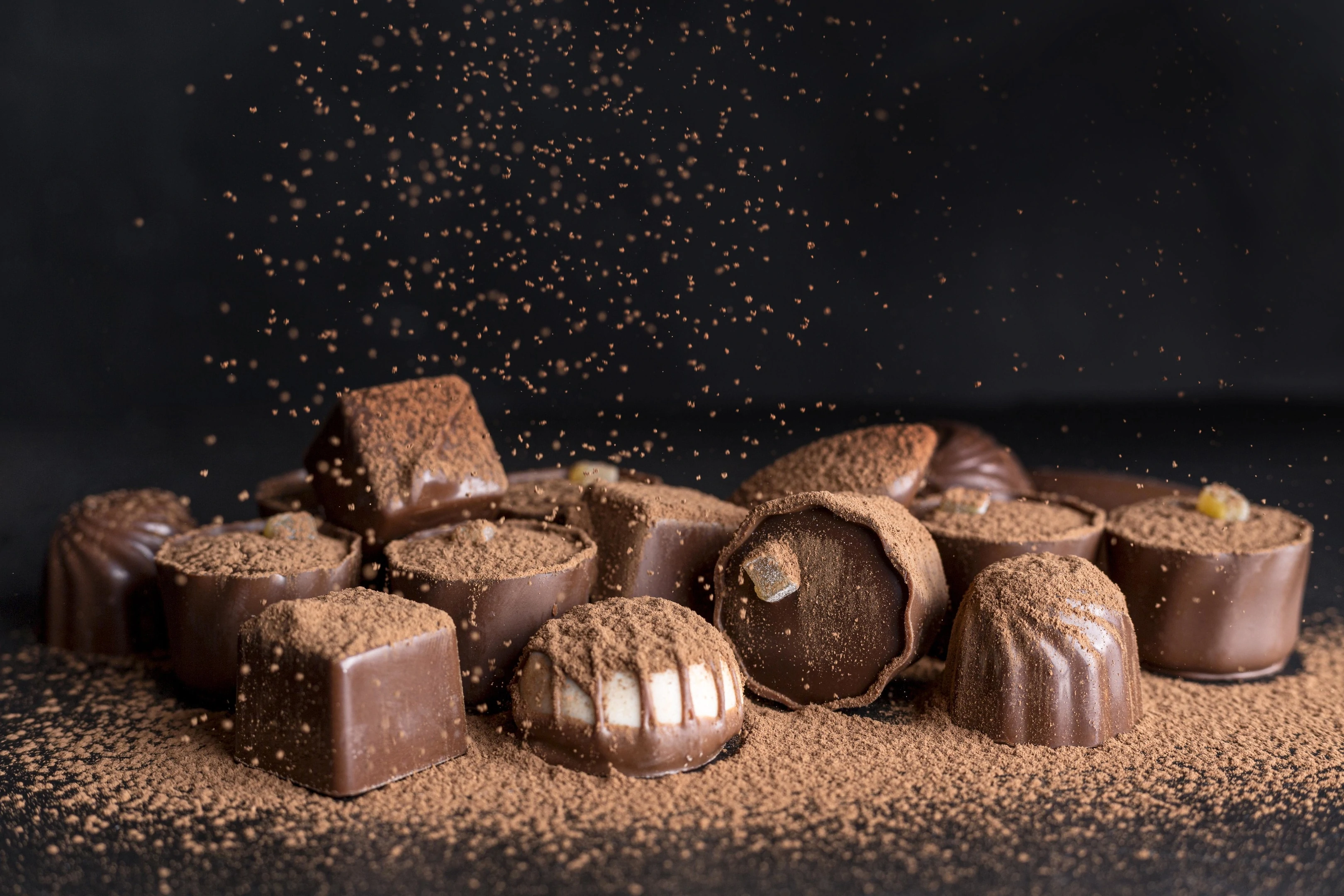 Variety of chocolate candies with cocoa powder