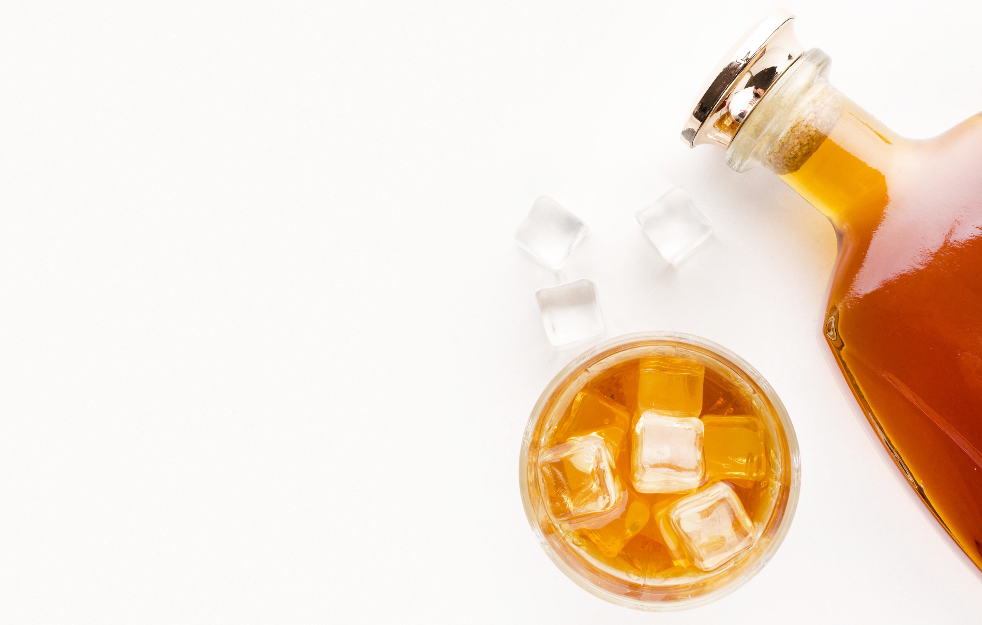 Whiskey bottle with glass on white background