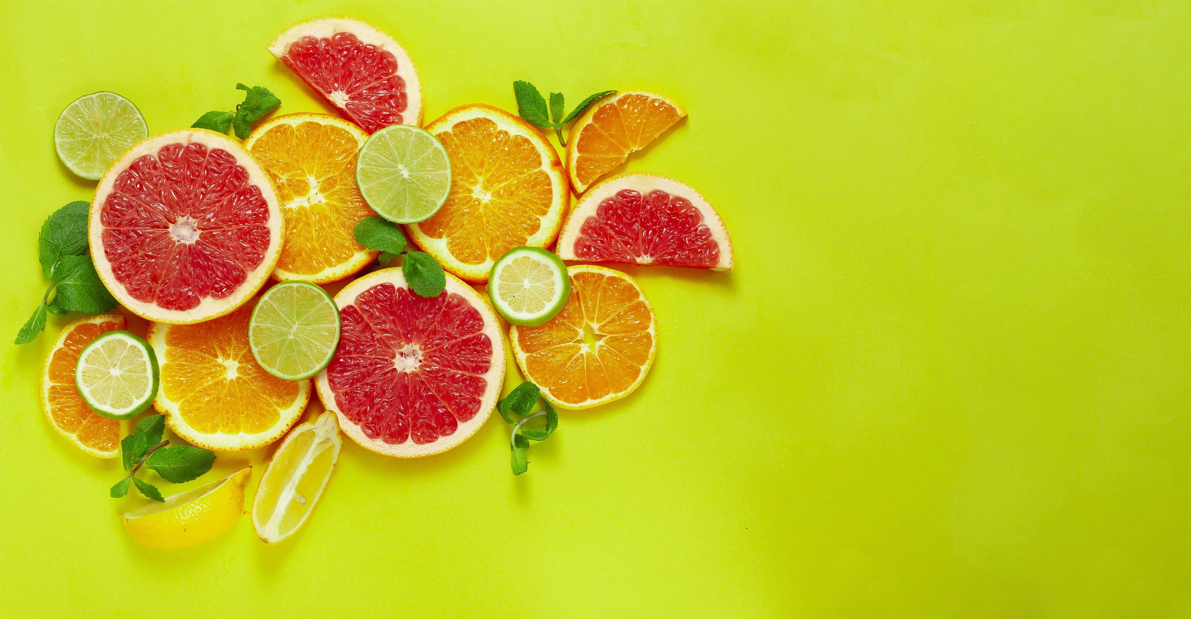 Assortment of citrus fruits on yellow background