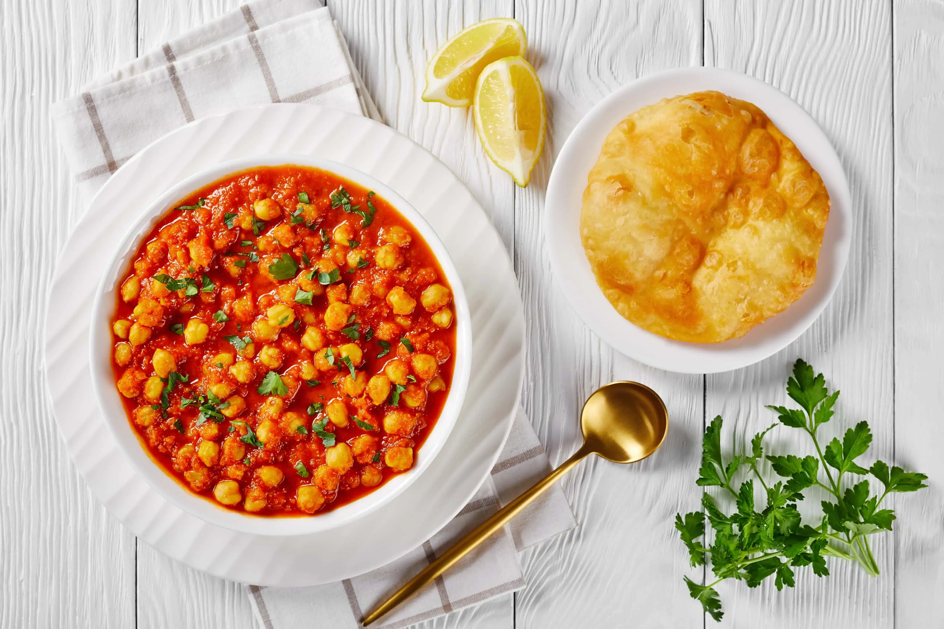 Chana masala chickpea curry with spices and tomato sauce served with indian fried bread bhatura