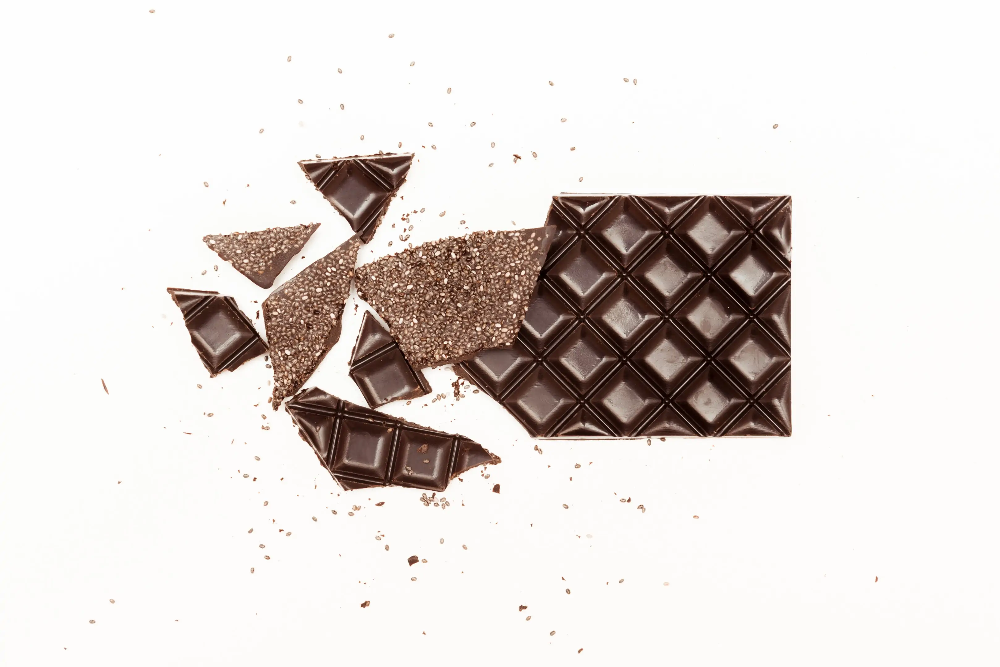 Cracked dark chocolate bar with chia seeds on white background