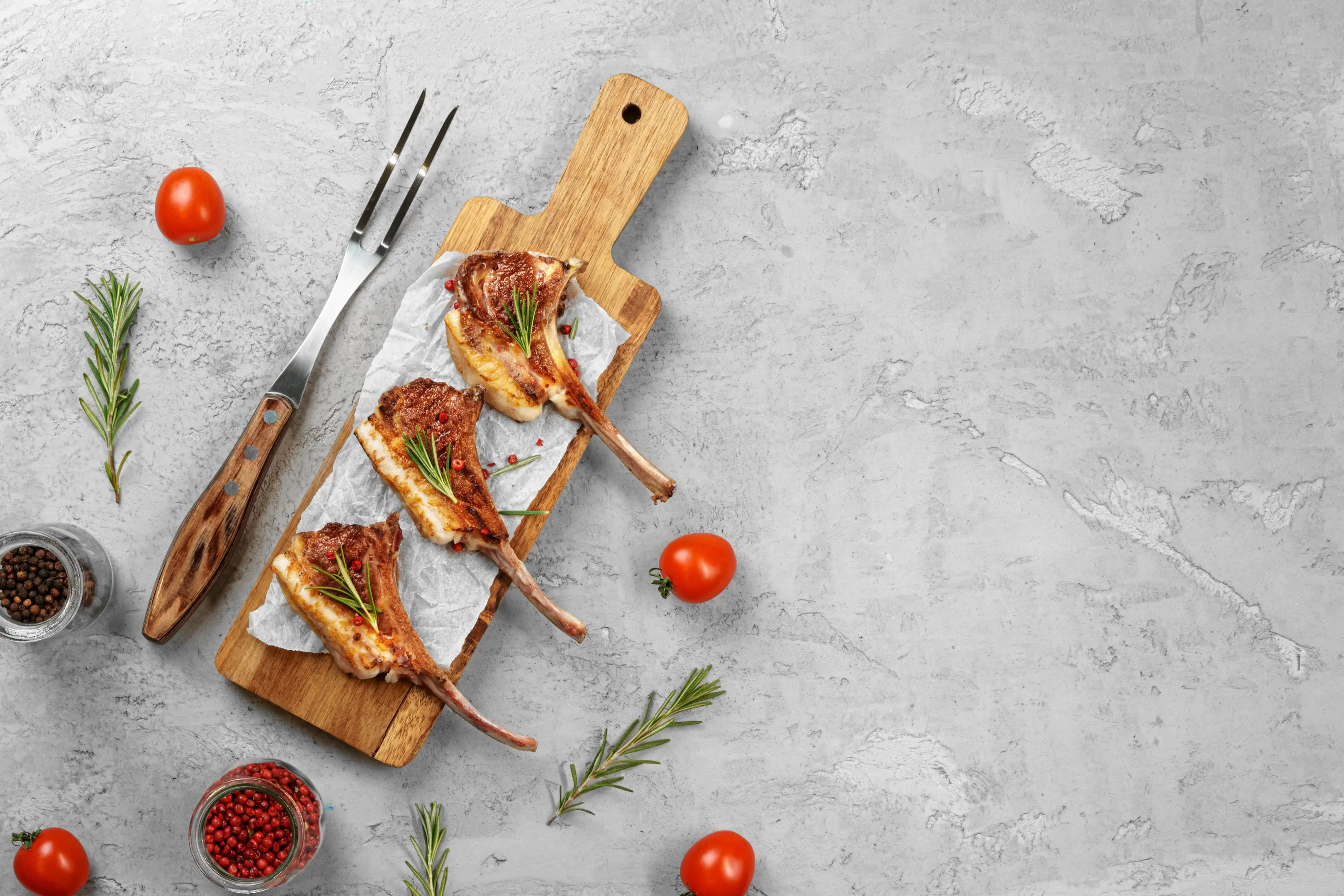 Grilled rack of lamb served on wooden board