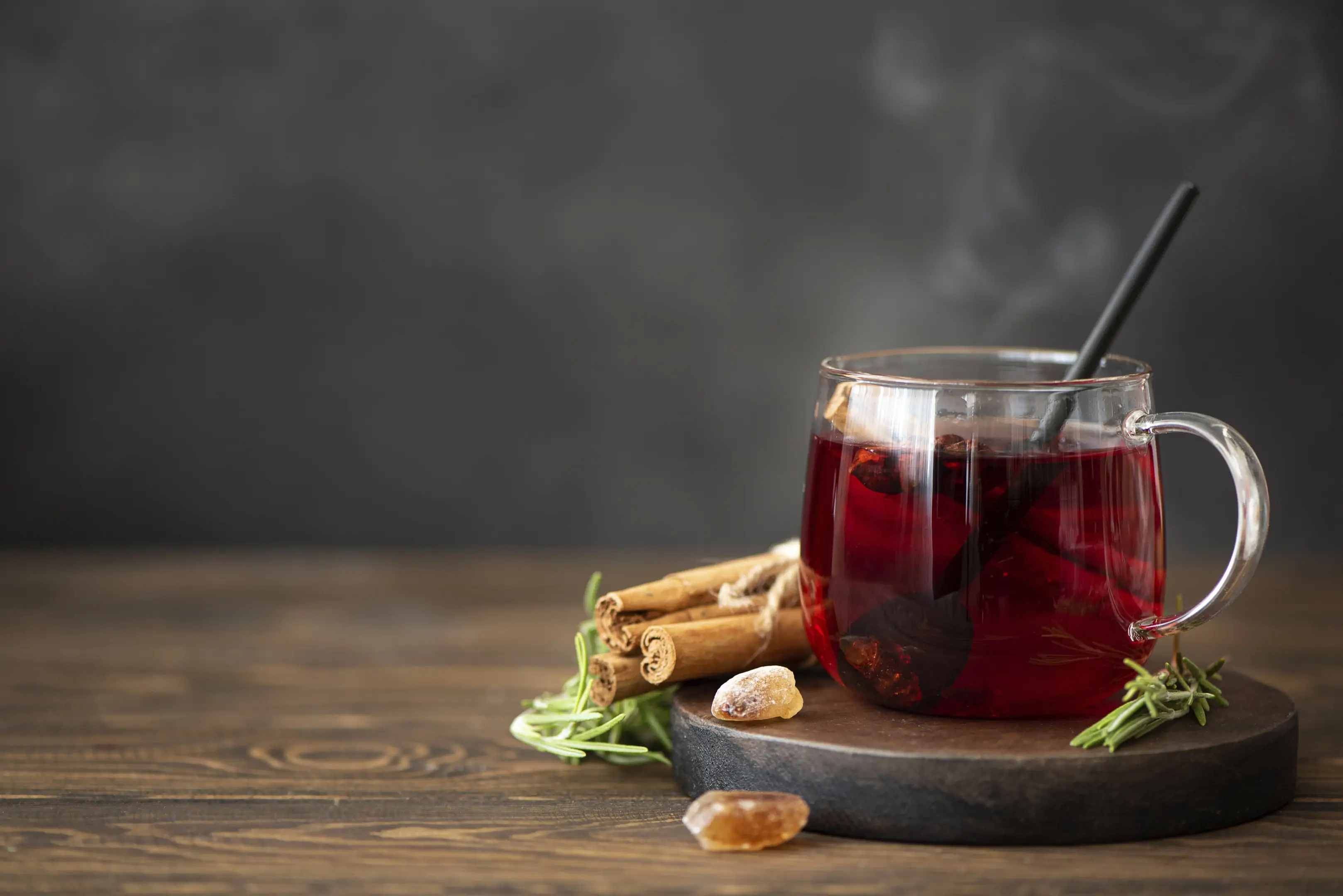 Hot hibiscus tea with cinnamon on wooden table