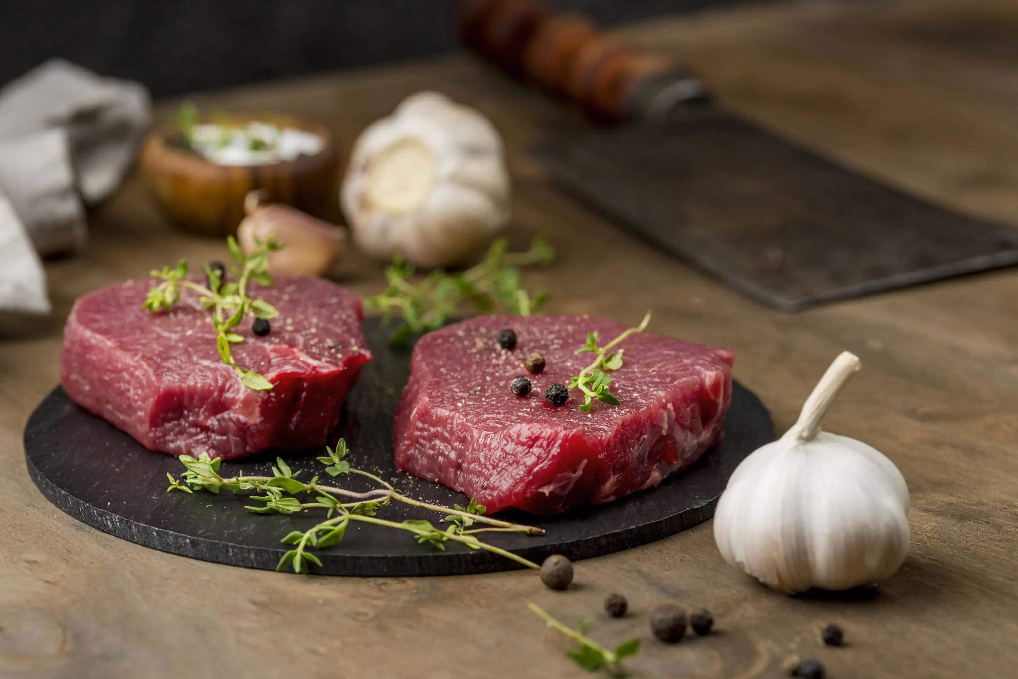 Lean meat with herbs and garlic on stone board