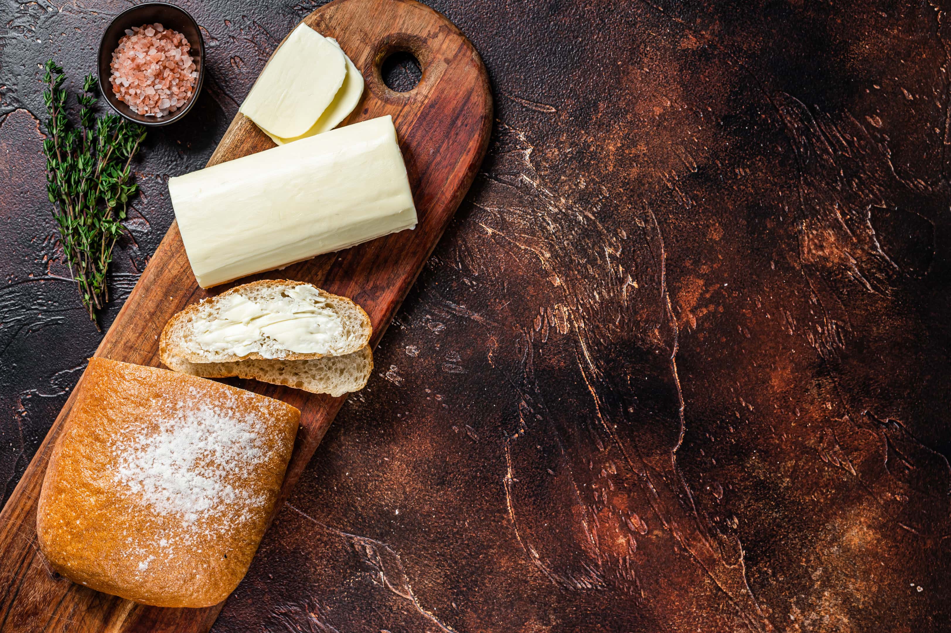 Margarine spreaded on toasts on wooden cutting board