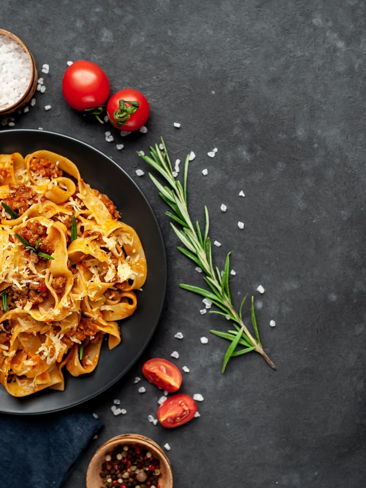 Pasta bolognese with spices on dark plate