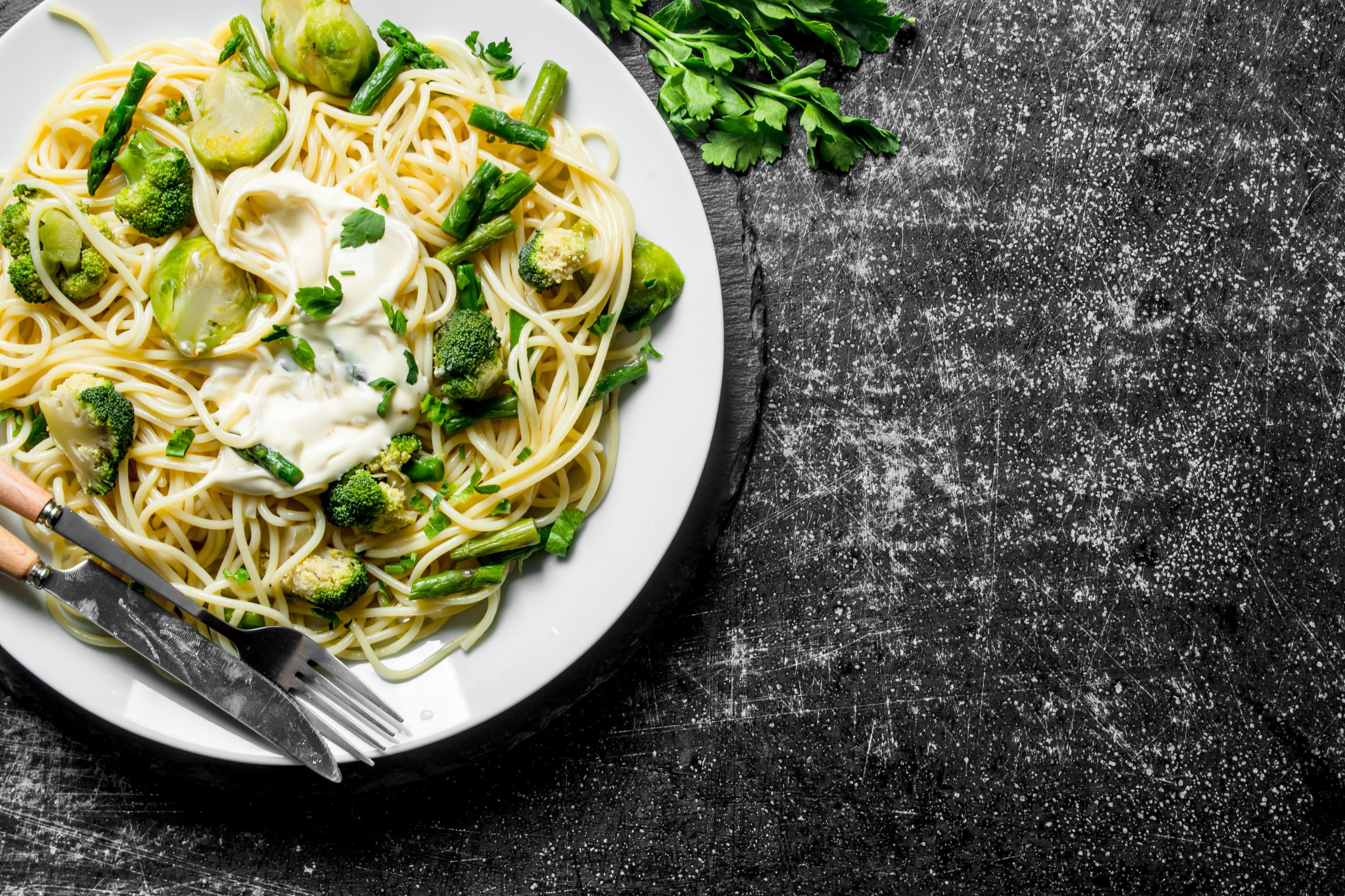 Pasta with broccoli, brussels sprouts and green beans on rustic table