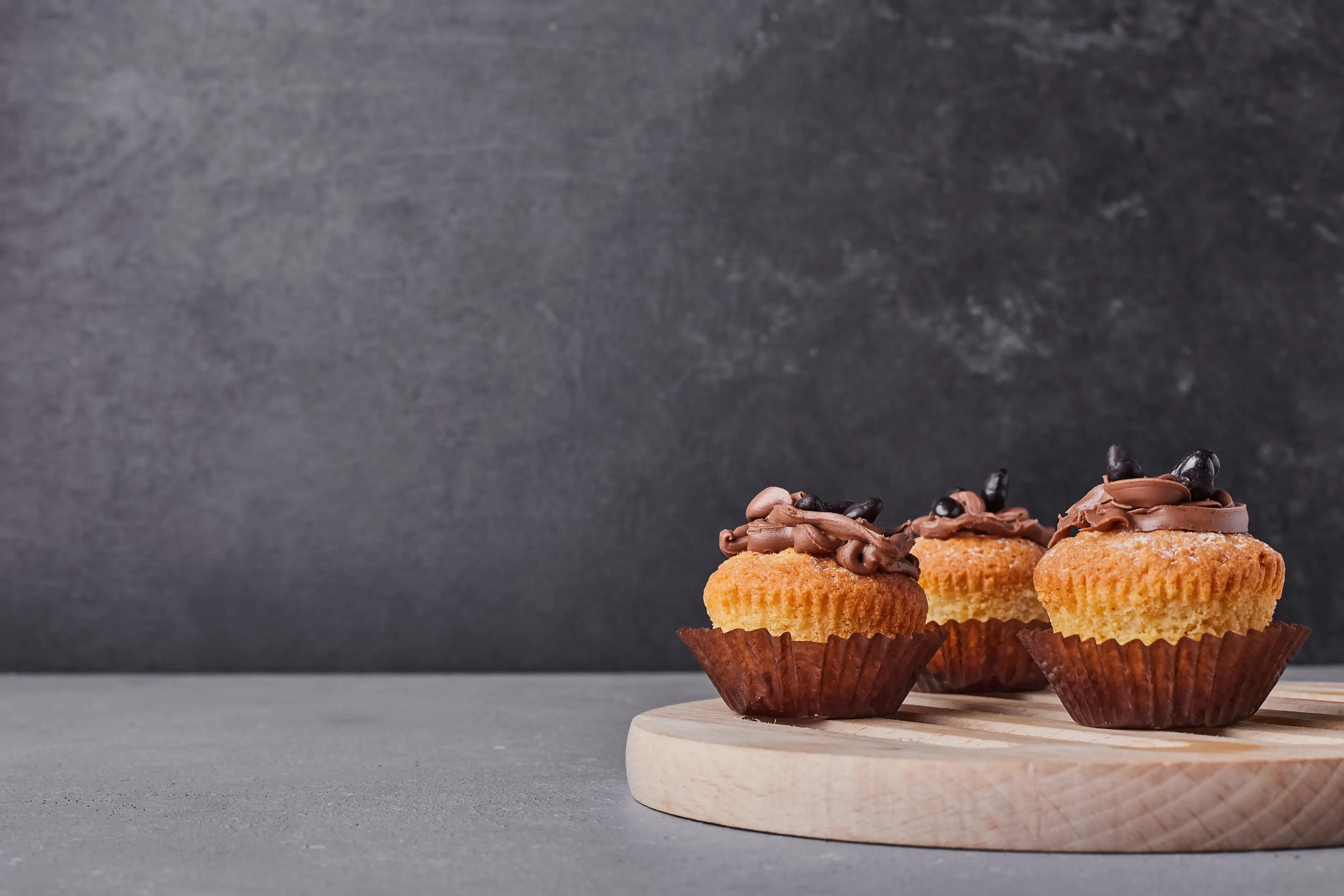 Plantain flour cupcakes with chocolate cream on wooden platter