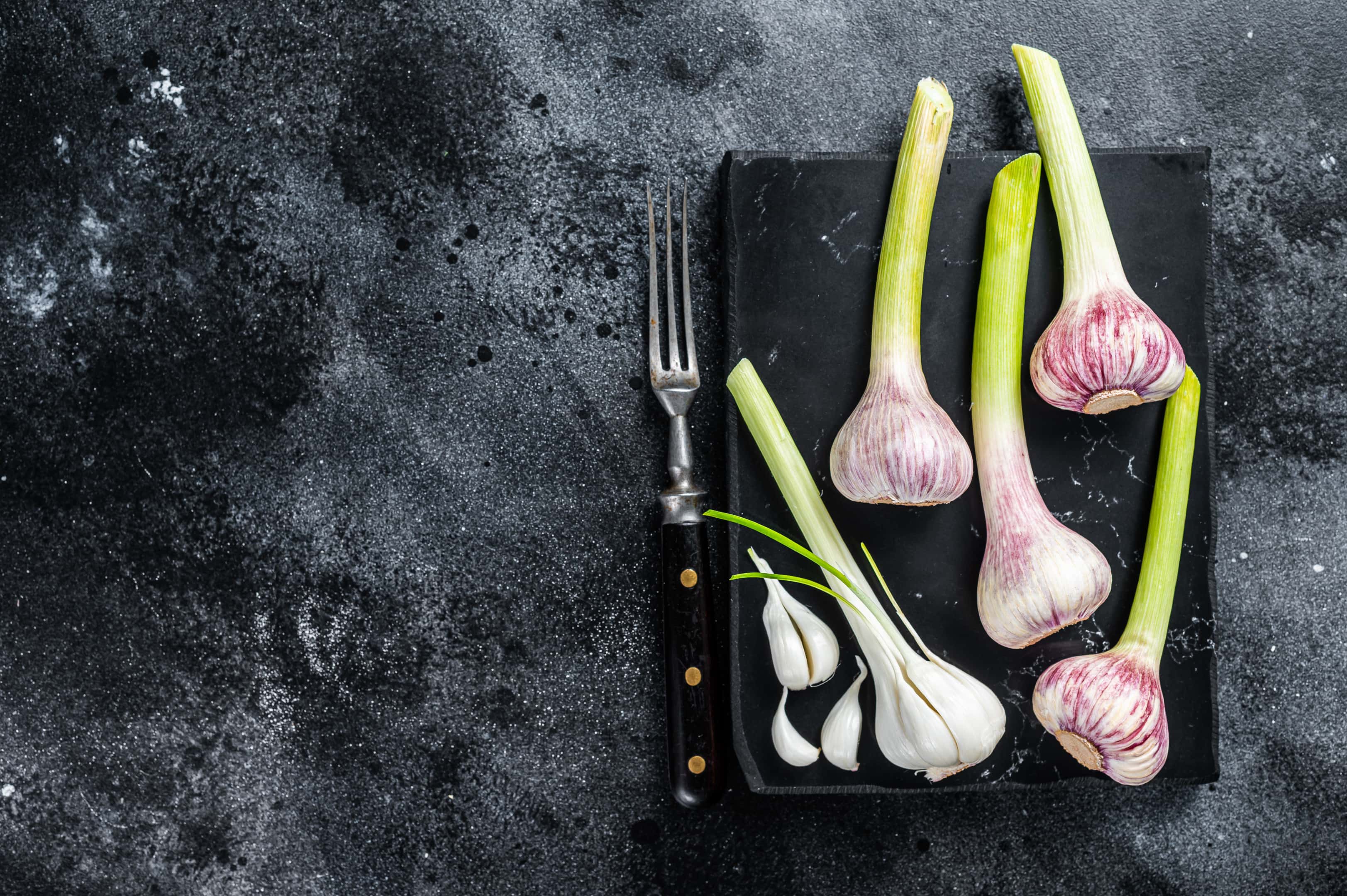 Raw spring of young garlic on marble board
