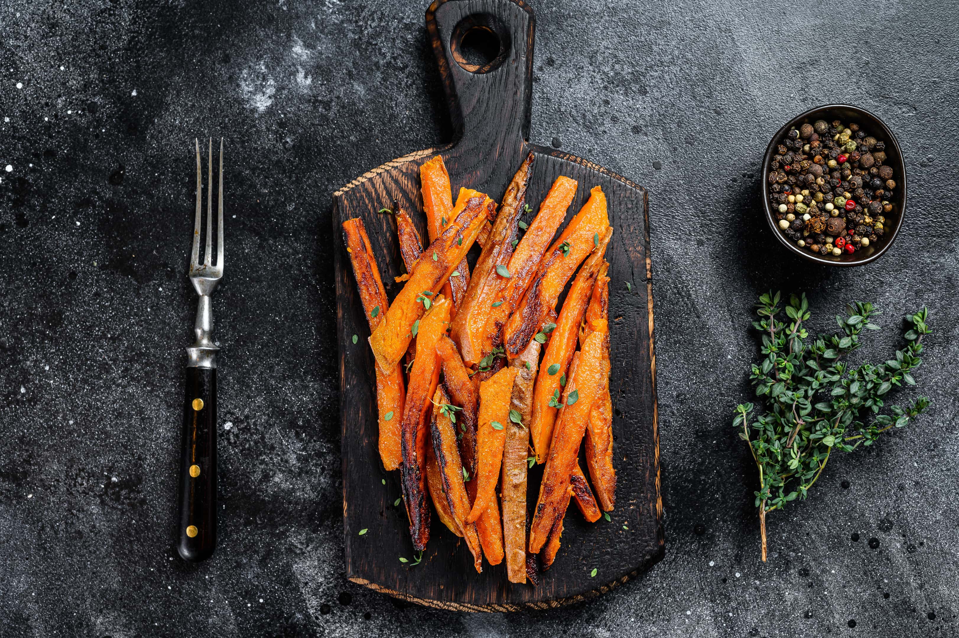 Roasted sweet potatoes stripes on wooden board