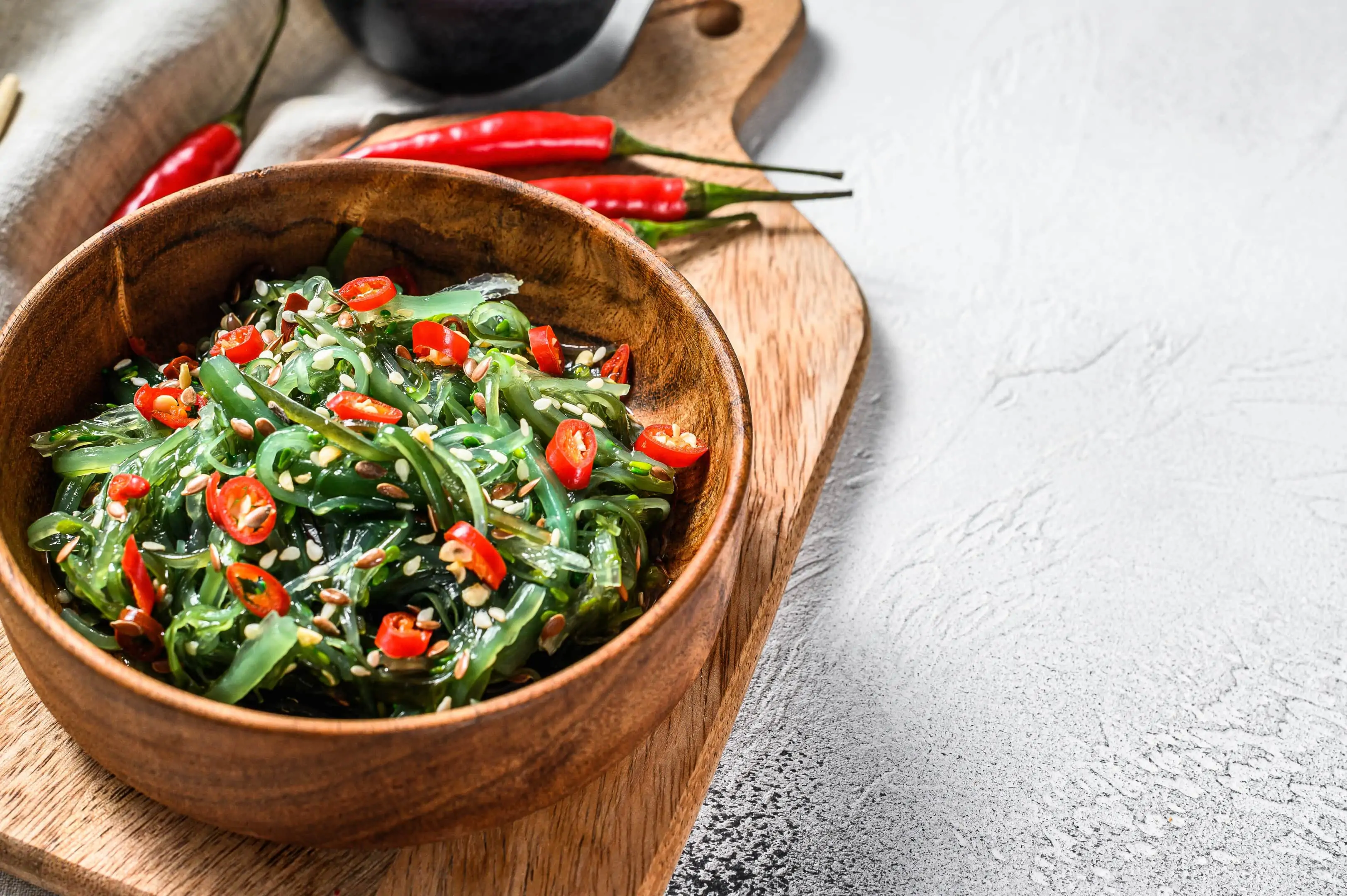 Salad with seaweed wakame and red chili pepper in wooden bowl