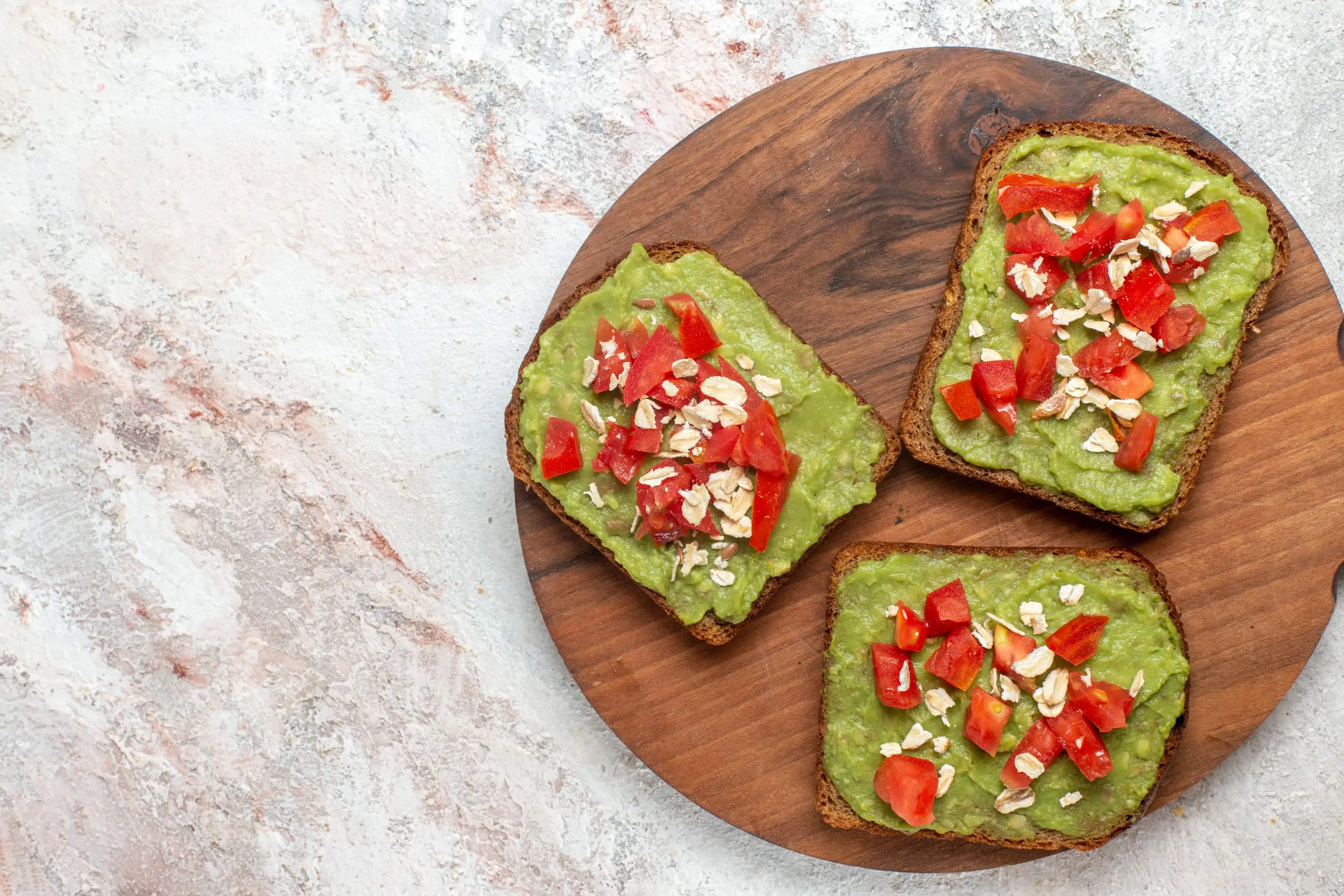 Avocado sandwiches with sliced red tomatoes and oats