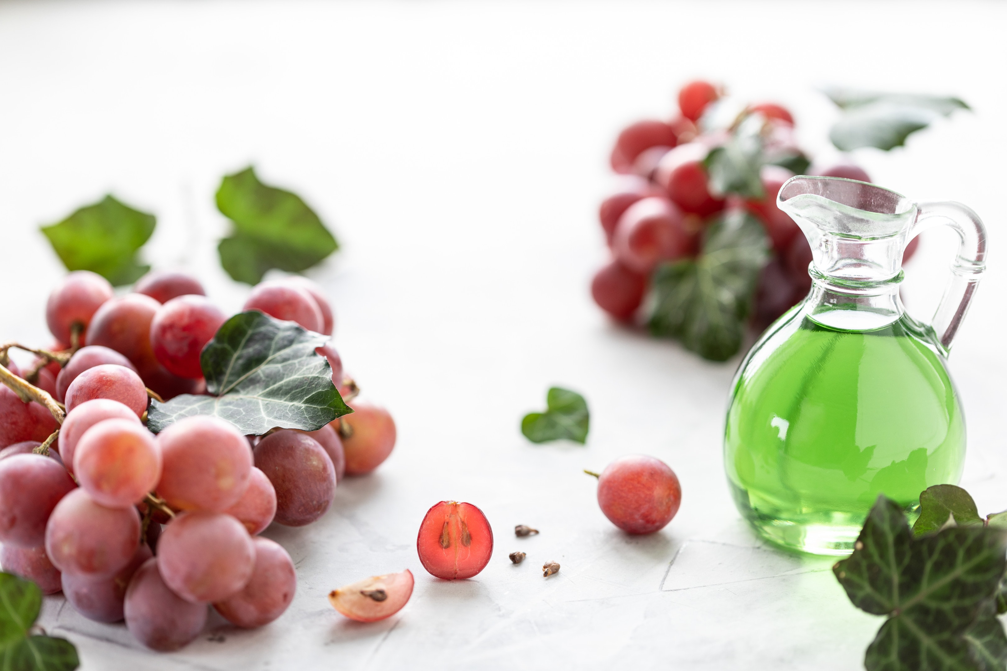 Grape seed extract in glass bottle with bunch of fresh grapes