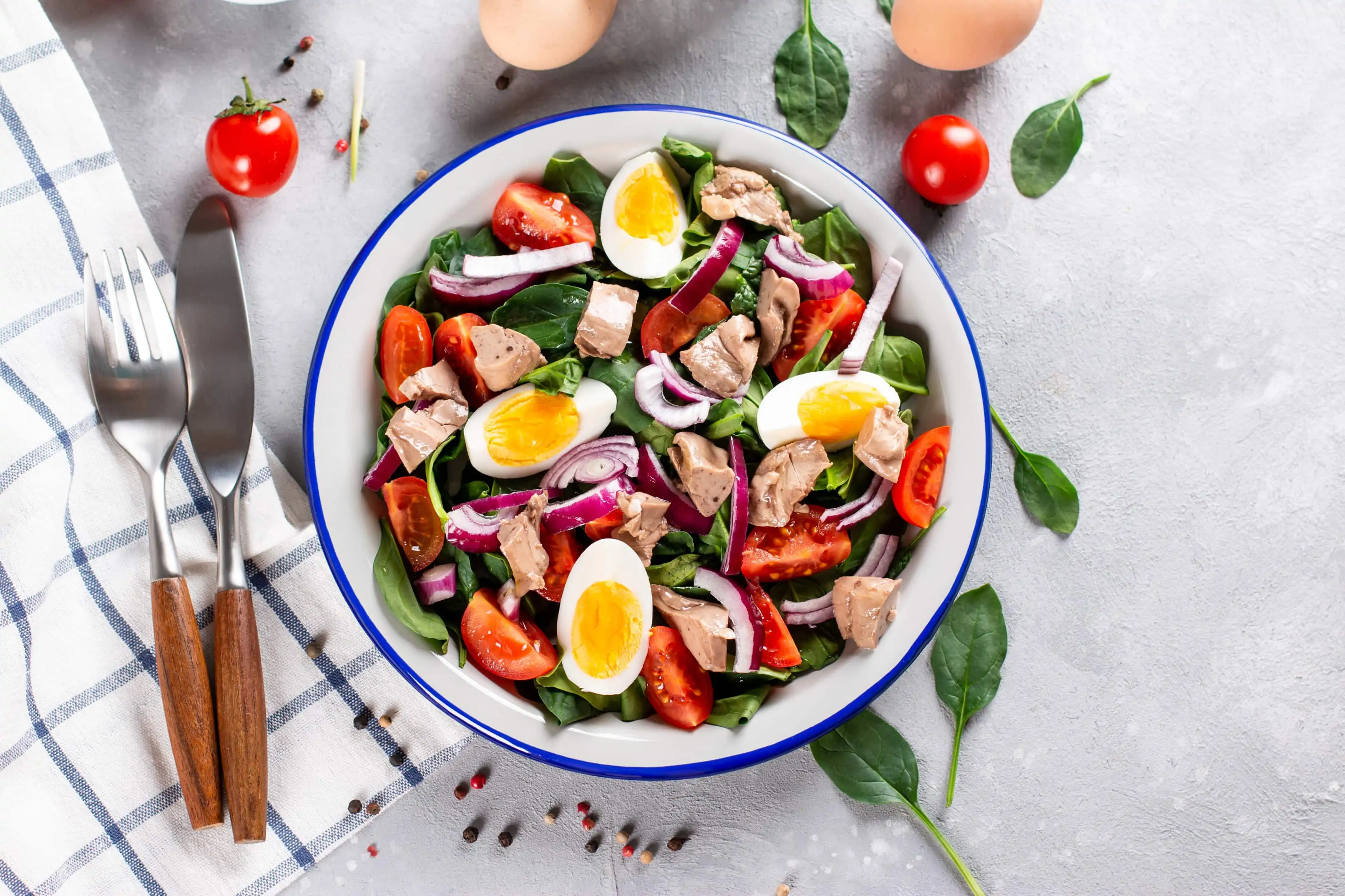 Salad of codfish liver with eggs, spinach and tomato