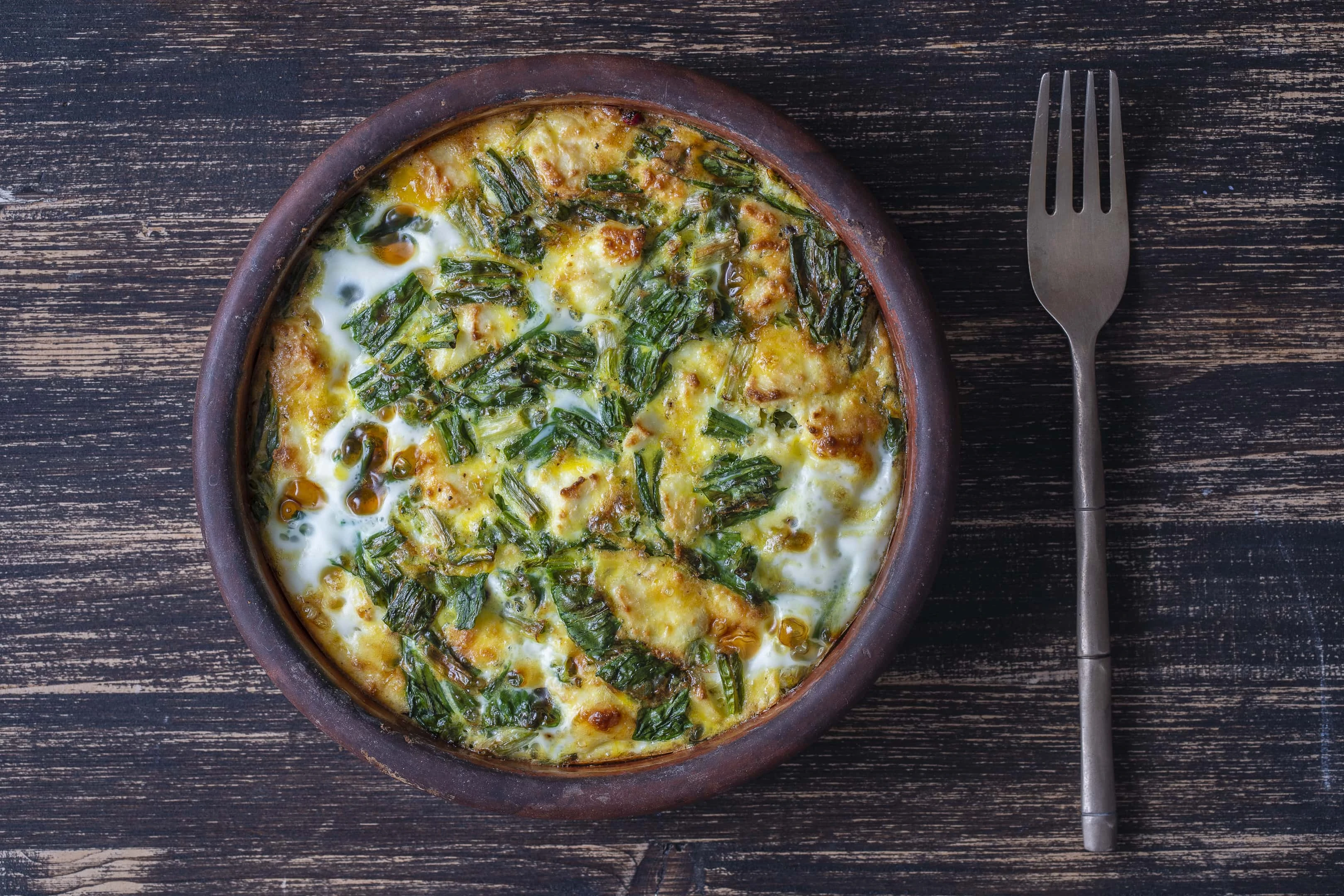 Vegetarian frittata with ramps wild leeks leaves, pepper, onion, cheese and green wild garlic leaves